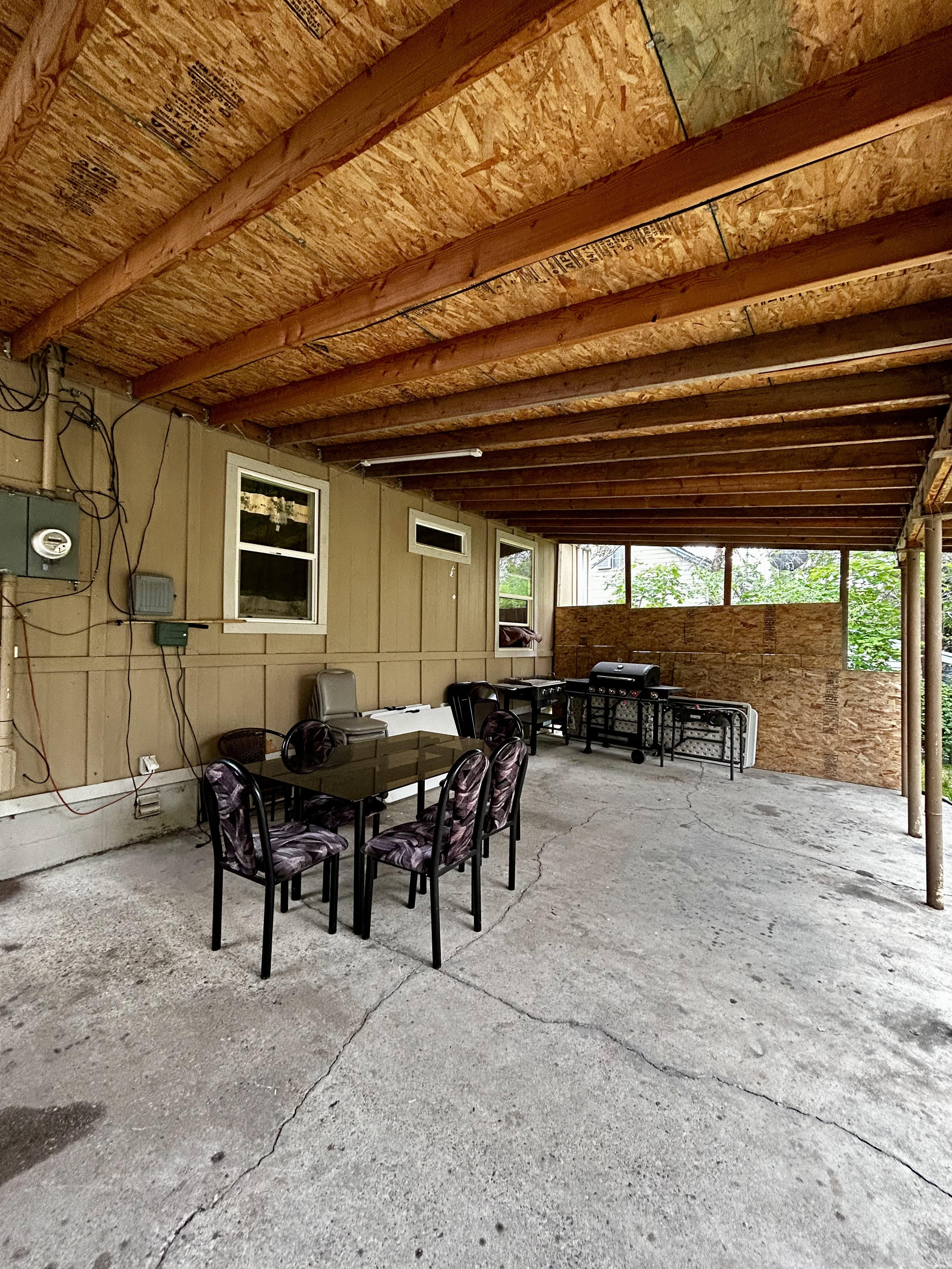 Covered outdoor concrete patio with exposed wood joists.