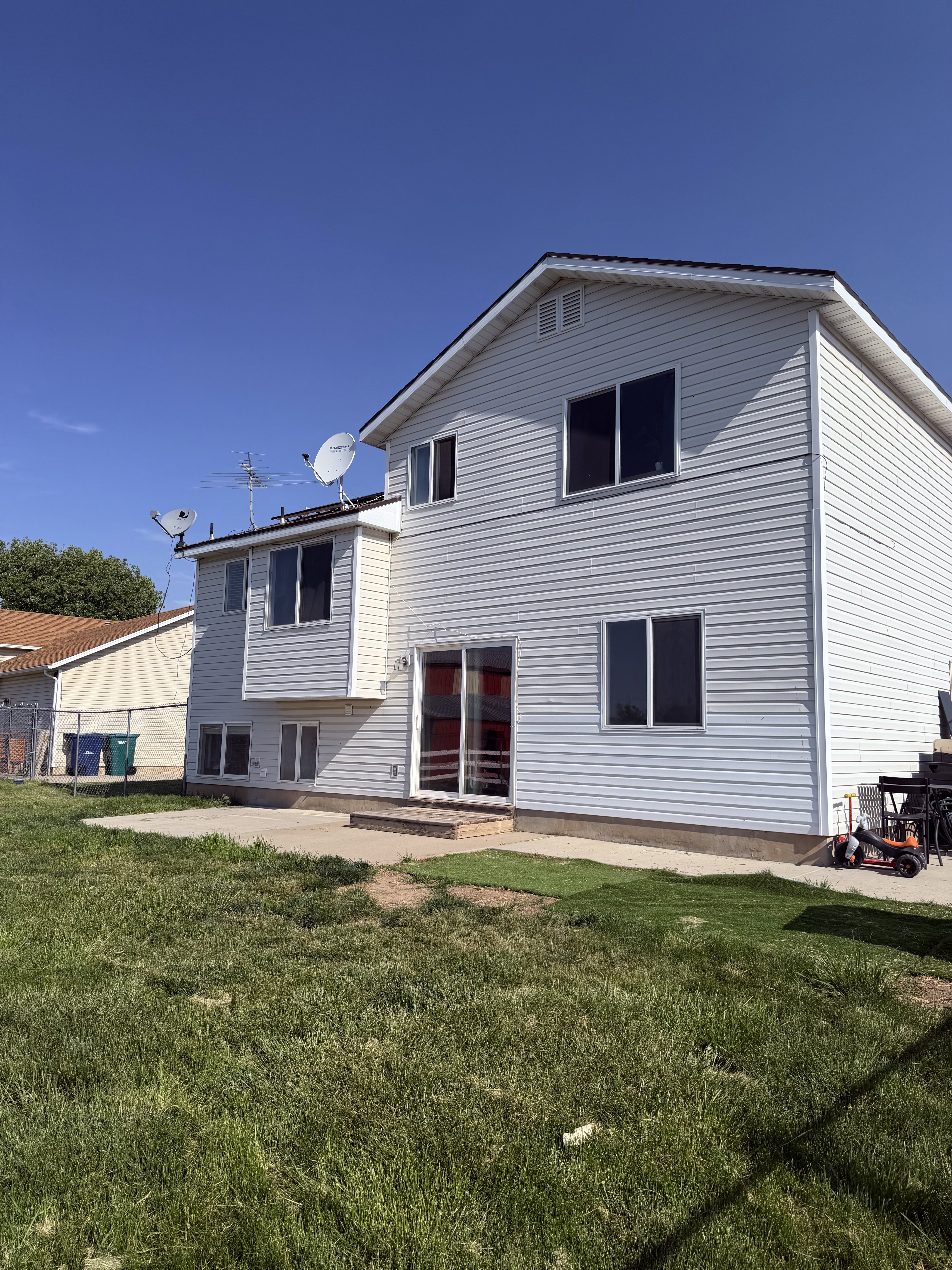 Two-story residence featuring light-colored siding and a dark shingle roof
