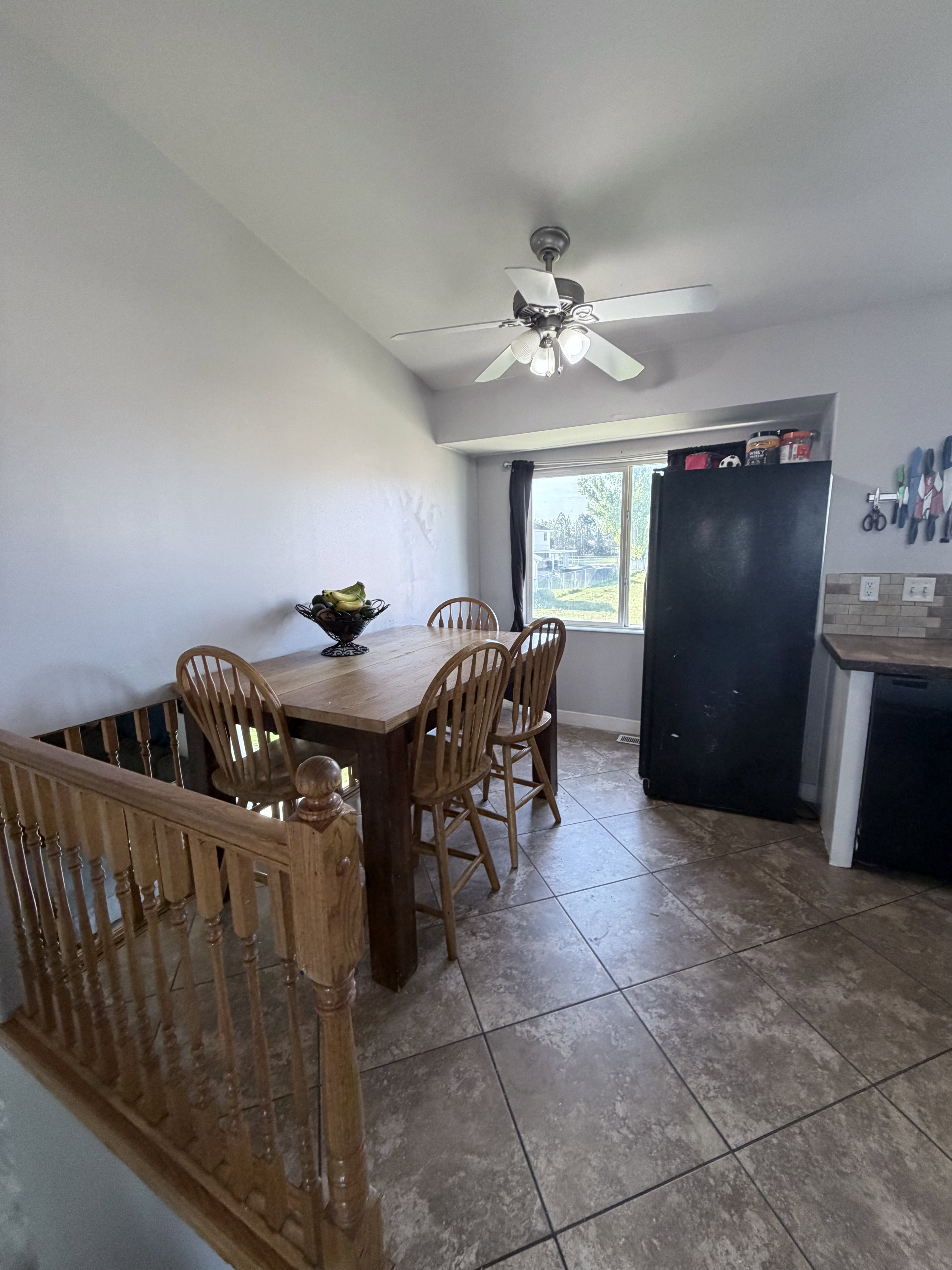 Dining area featuring neutral wall tones, a ceiling fan with integrated lighting, and tile flooring