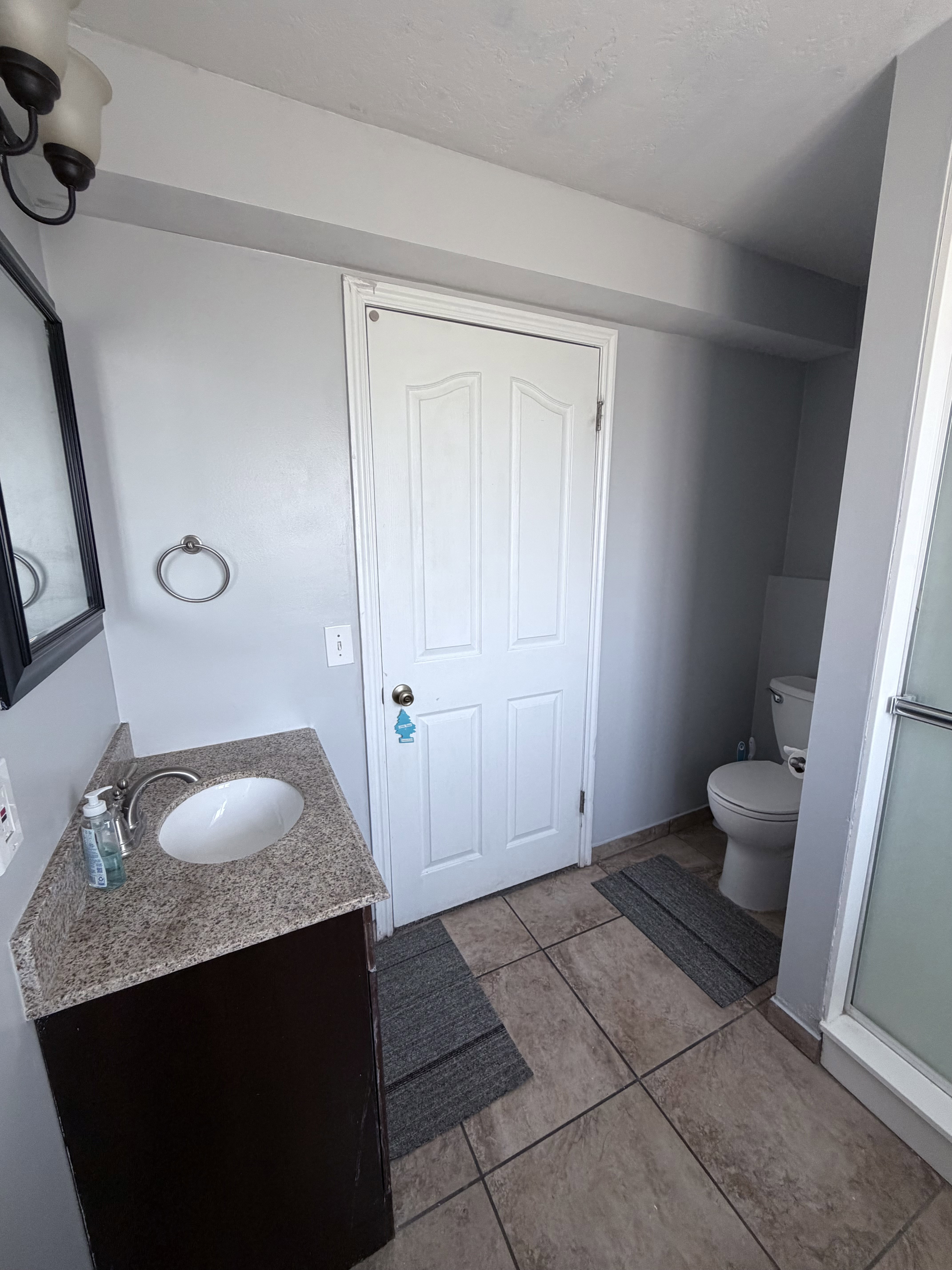 Bathroom featuring a dark wood-finish vanity with a granite countertop and an undermount sink