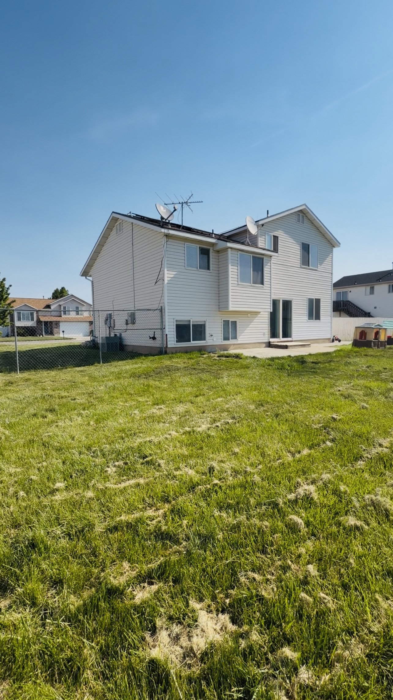 Spacious backyard with a chain-link fence, providing an expansive outdoor area