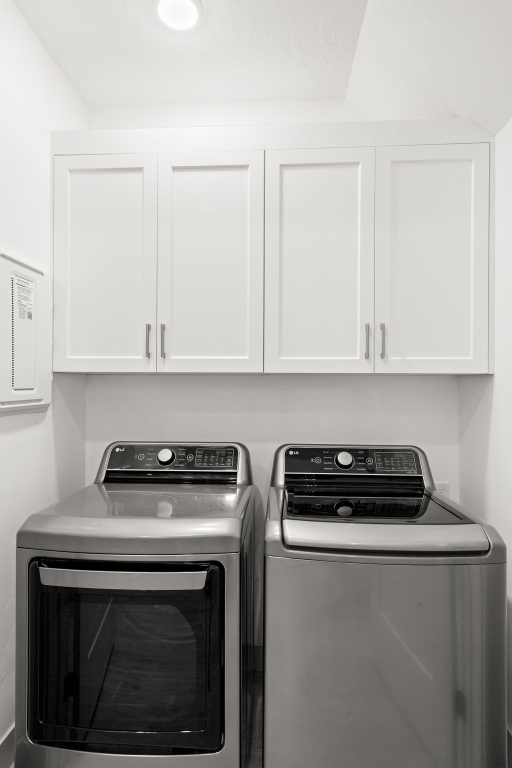 Laundry area featuring white shaker-style cabinetry with brushed nickel hardware, and a ceiling-mounted flush light fixture