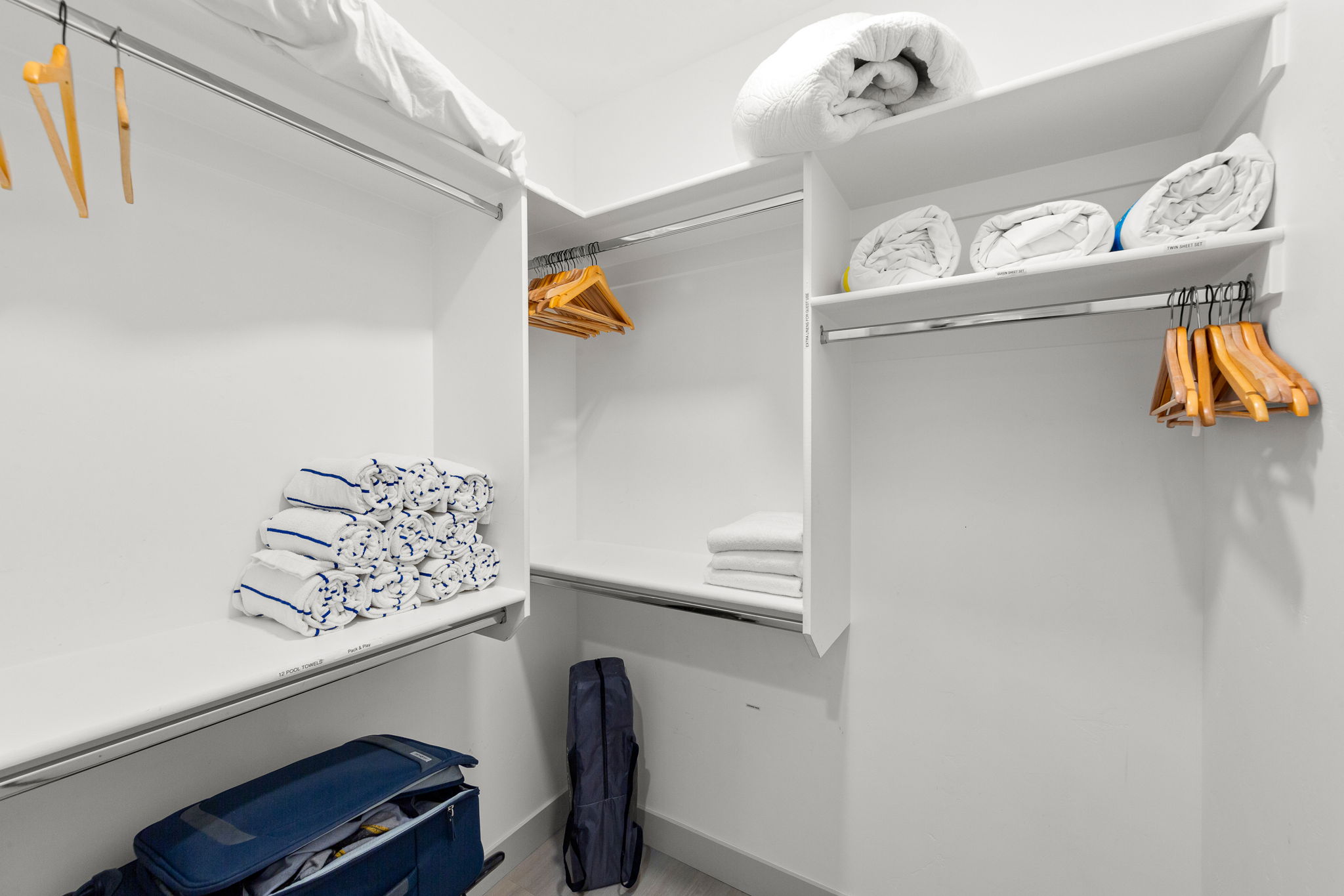 Custom built-in closet system featuring white shelving and chrome hanging rods