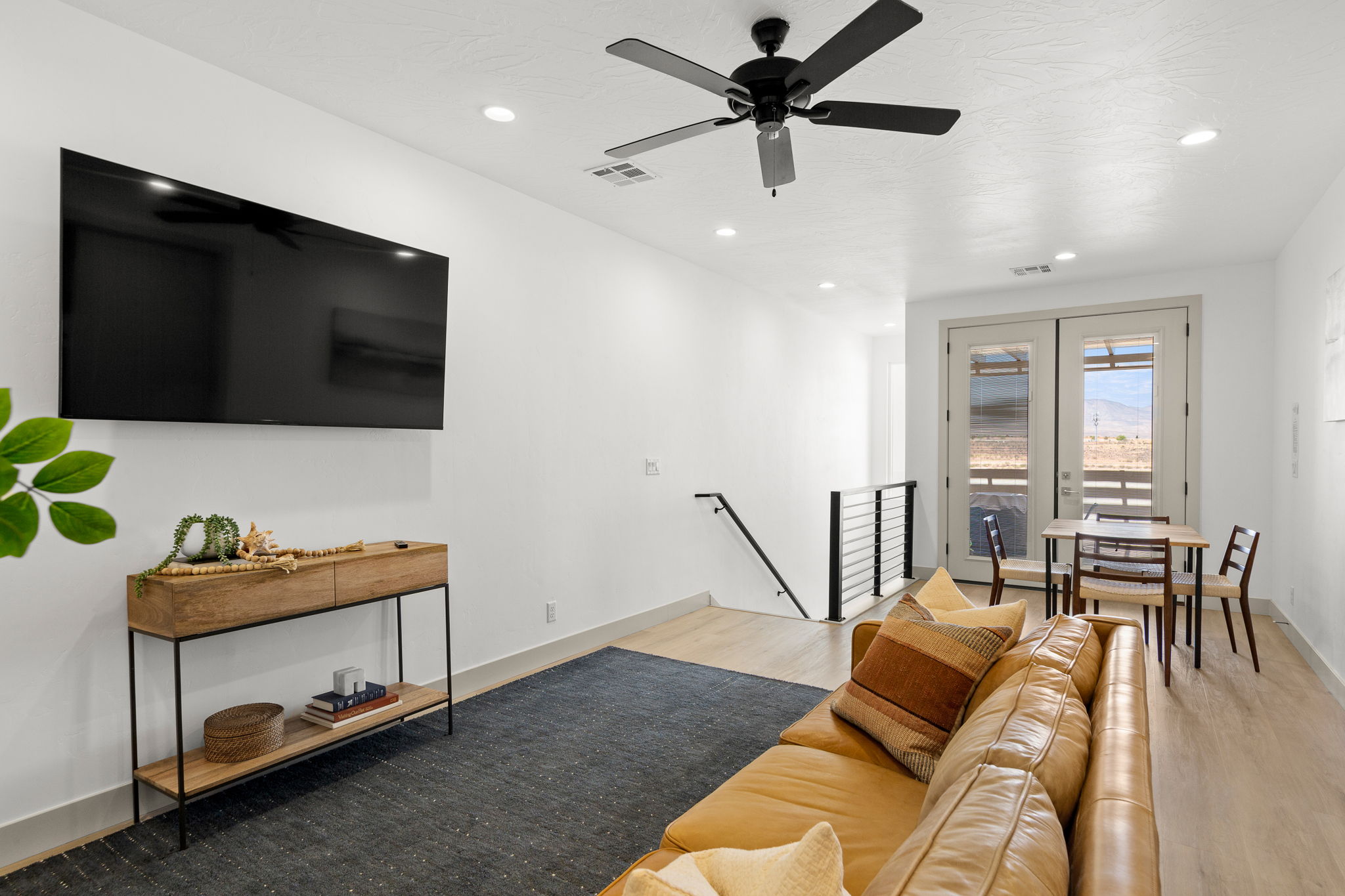 Open-concept living space with light wood-finish flooring, white walls, and recessed lighting