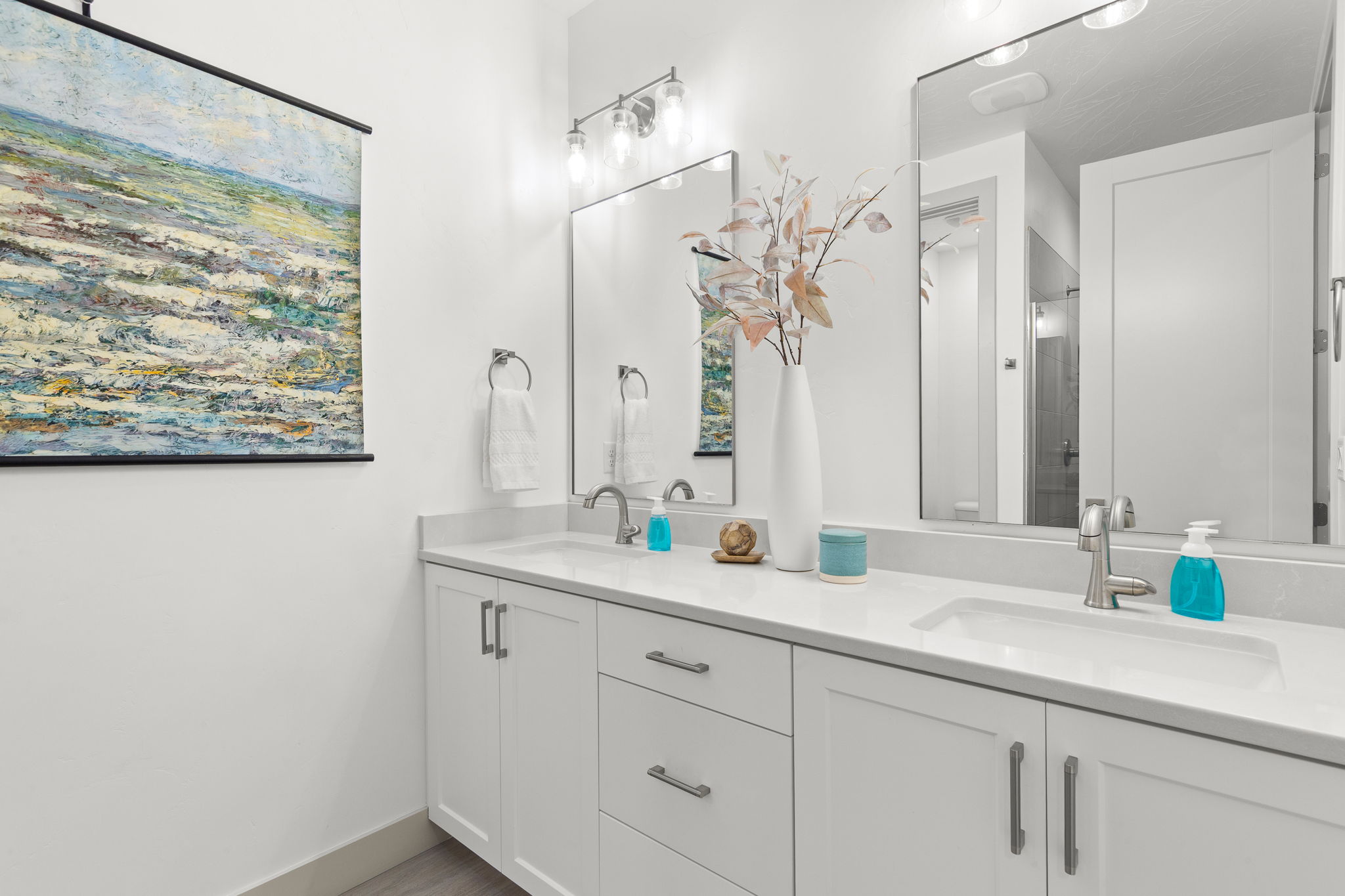 Dual vanity with undermount sinks, stone countertops, and chrome fixtures