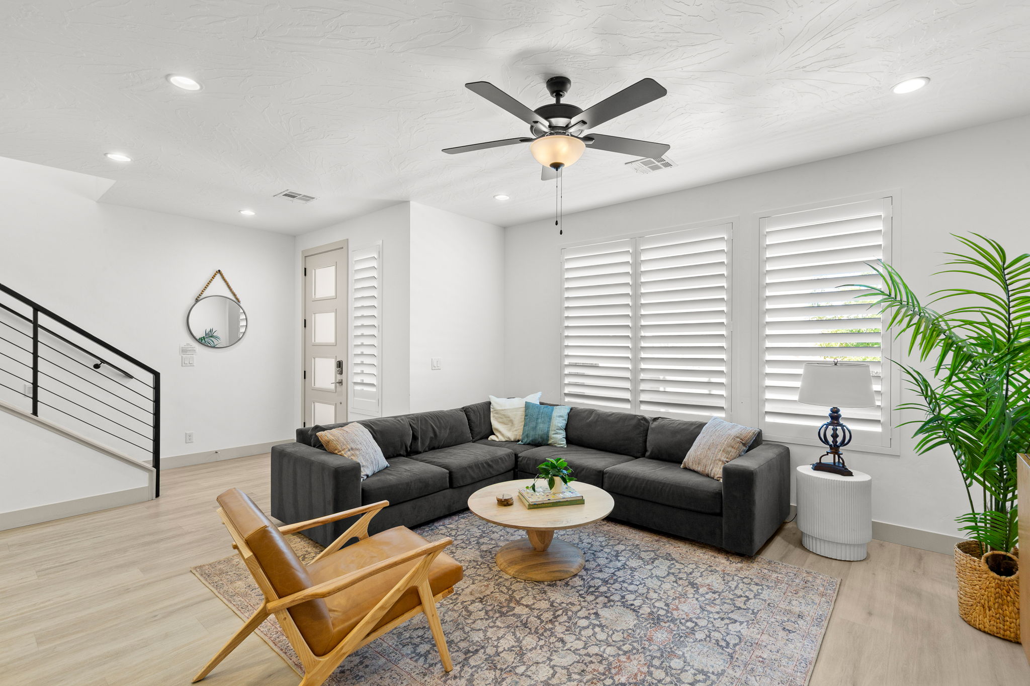 Open-concept living area featuring light wood-finish flooring, recessed lighting, and a contemporary ceiling fan