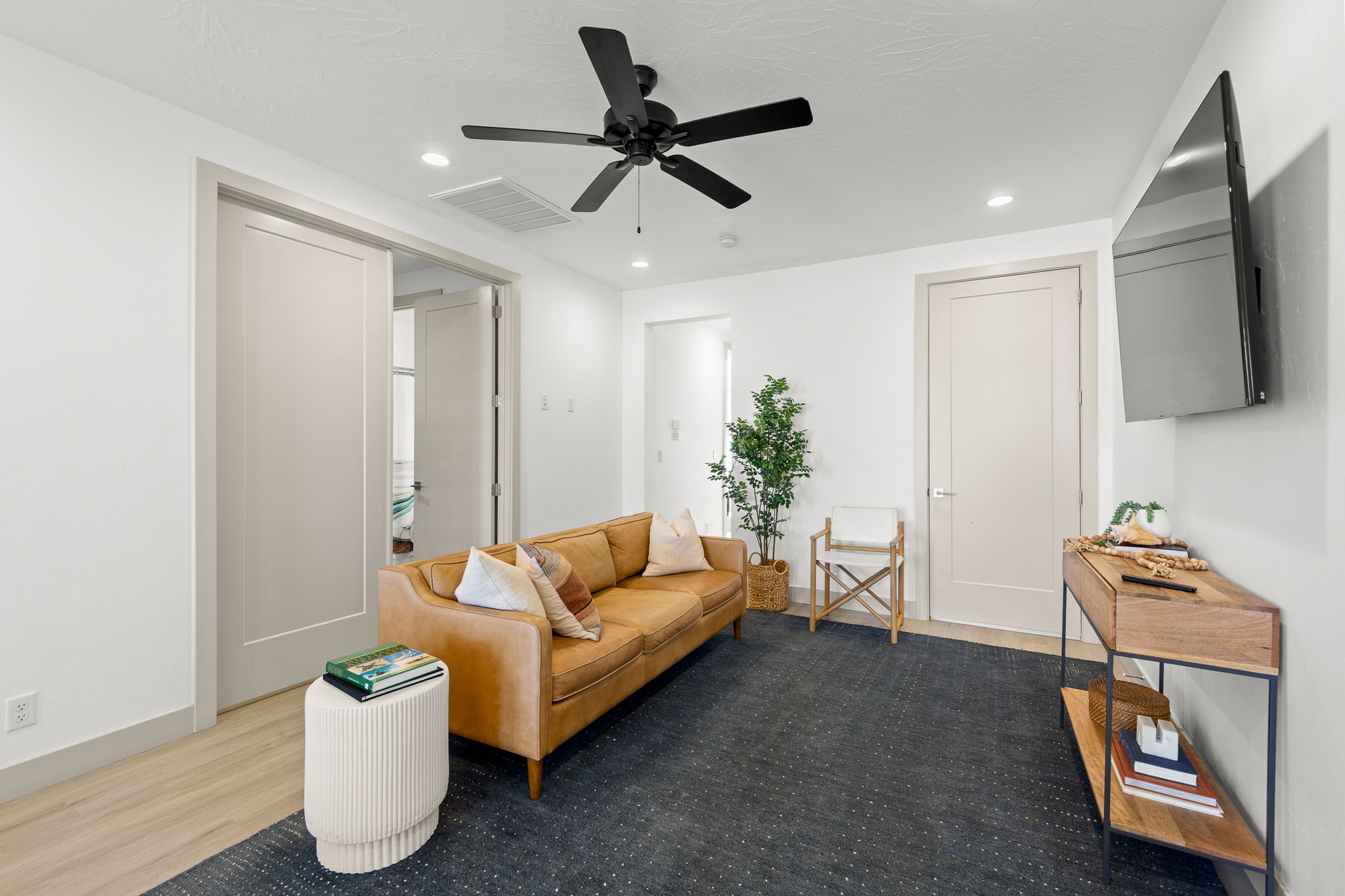 Living area featuring light wood-finish flooring, white walls, and recessed lighting