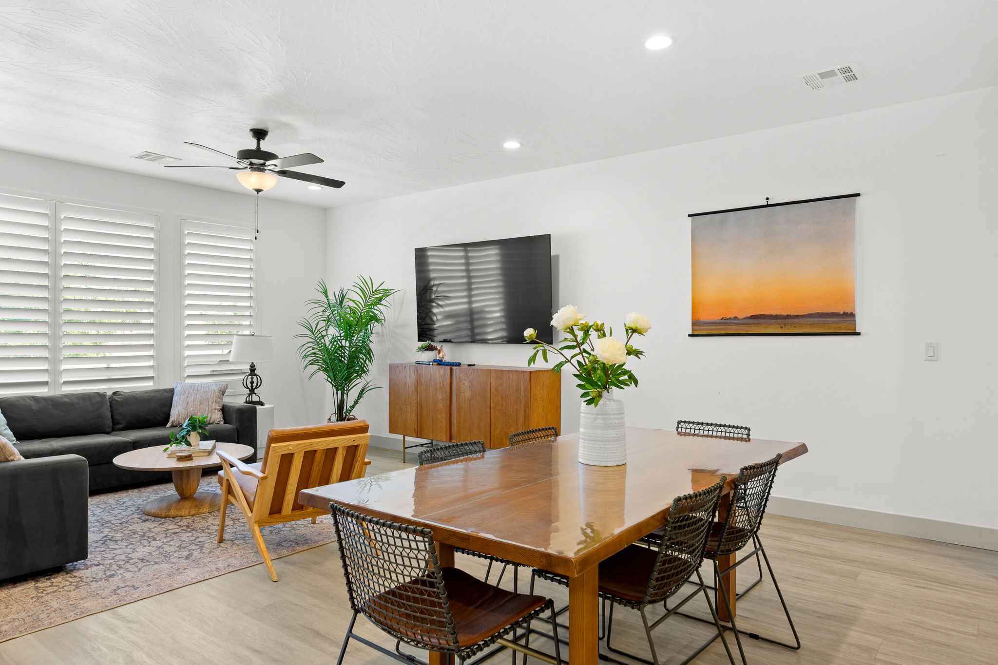 Open-concept living area featuring light wood-finish flooring, recessed lighting, and white walls