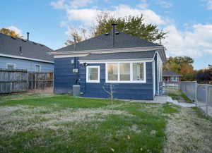 Rear exterior featuring blue horizontal siding, white trim, and a dark shingle roof