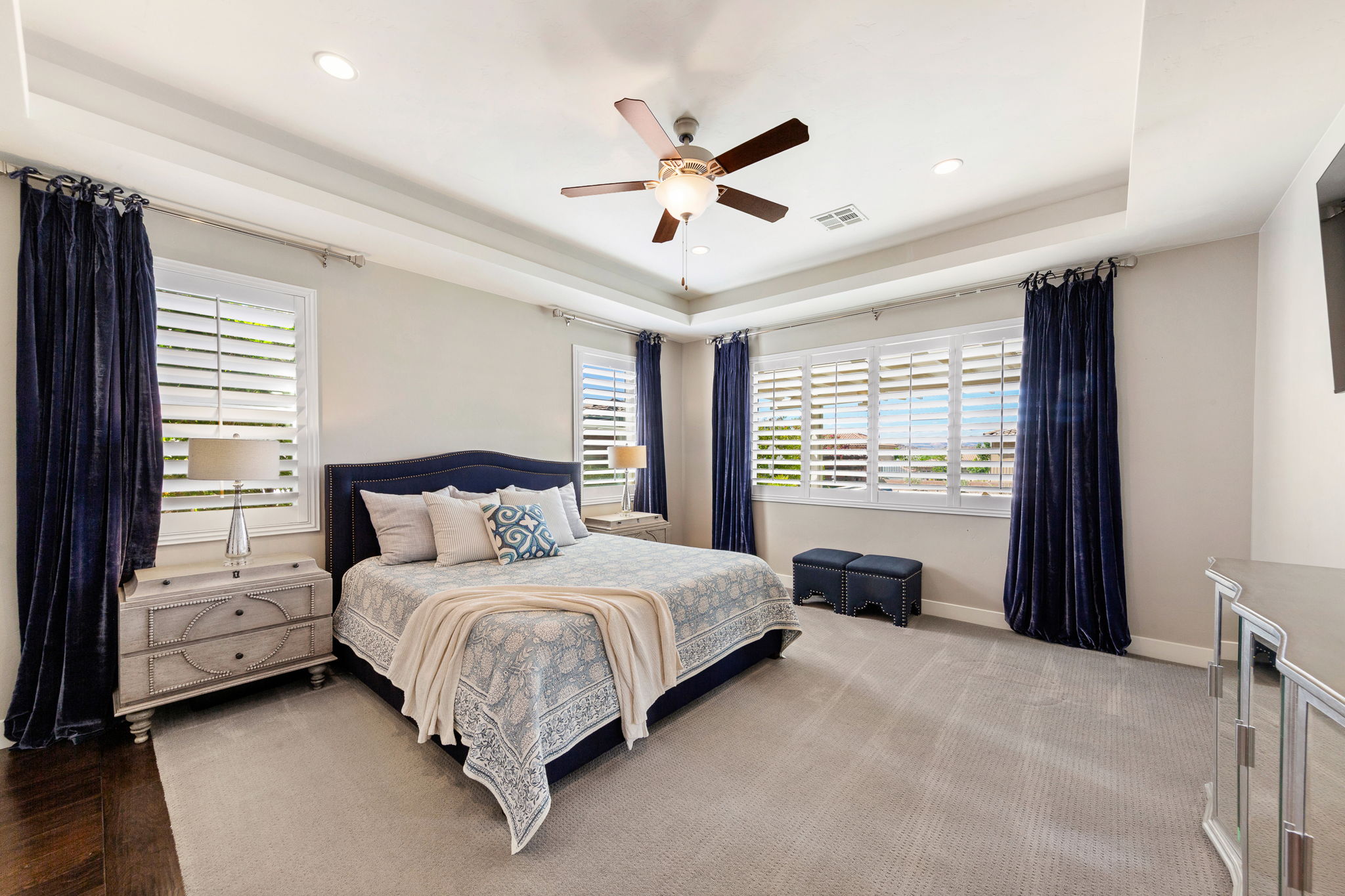 Carpeted room with a tray ceiling and recessed lighting