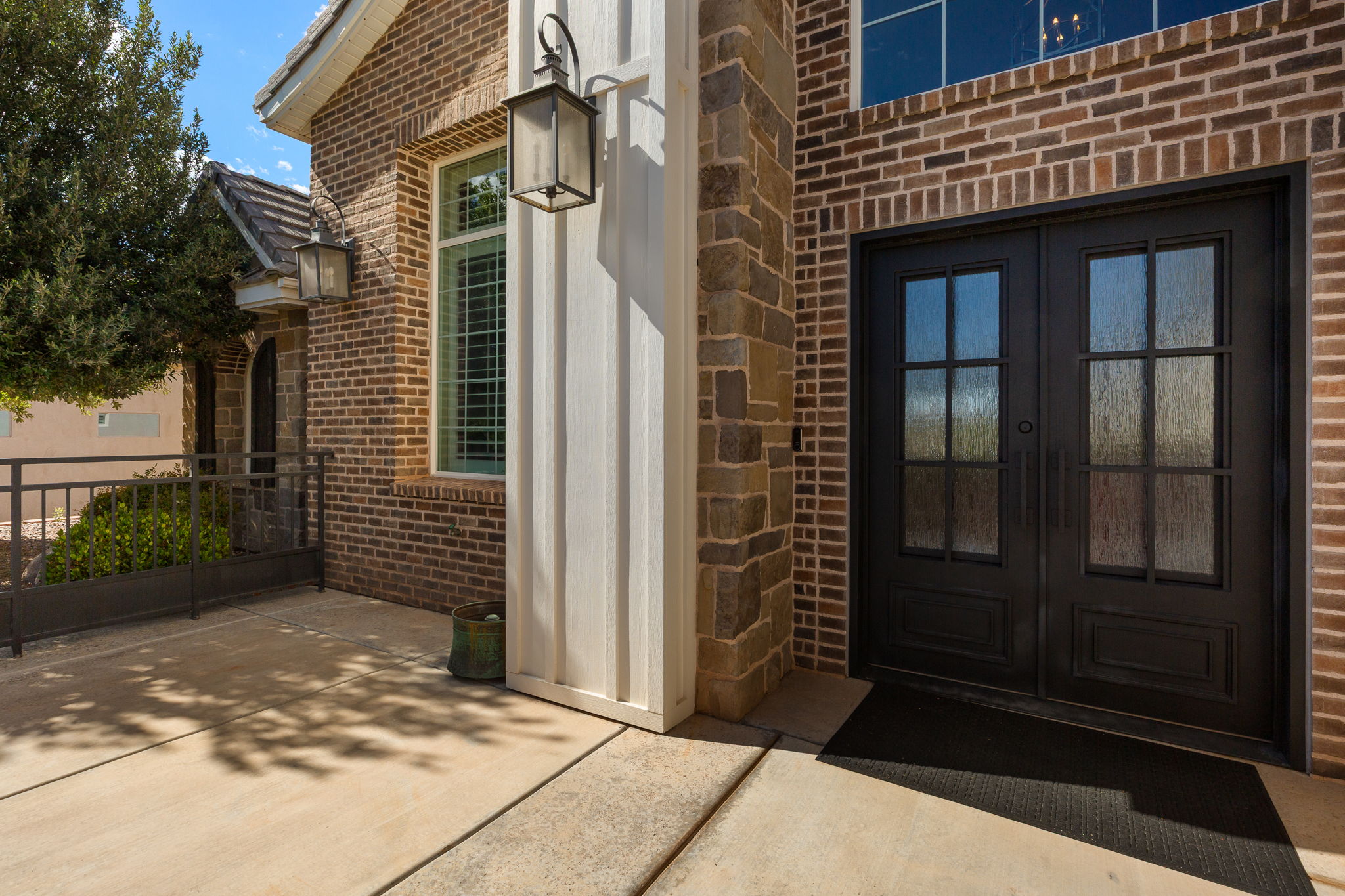 Brick and stone exterior featuring double entry doors with decorative glass panels