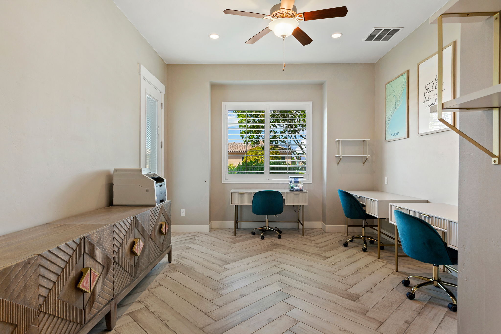 Herringbone wood-finish flooring complements this room featuring a window with plantation shutters, a ceiling fan with integrated lighting, and recessed lighting