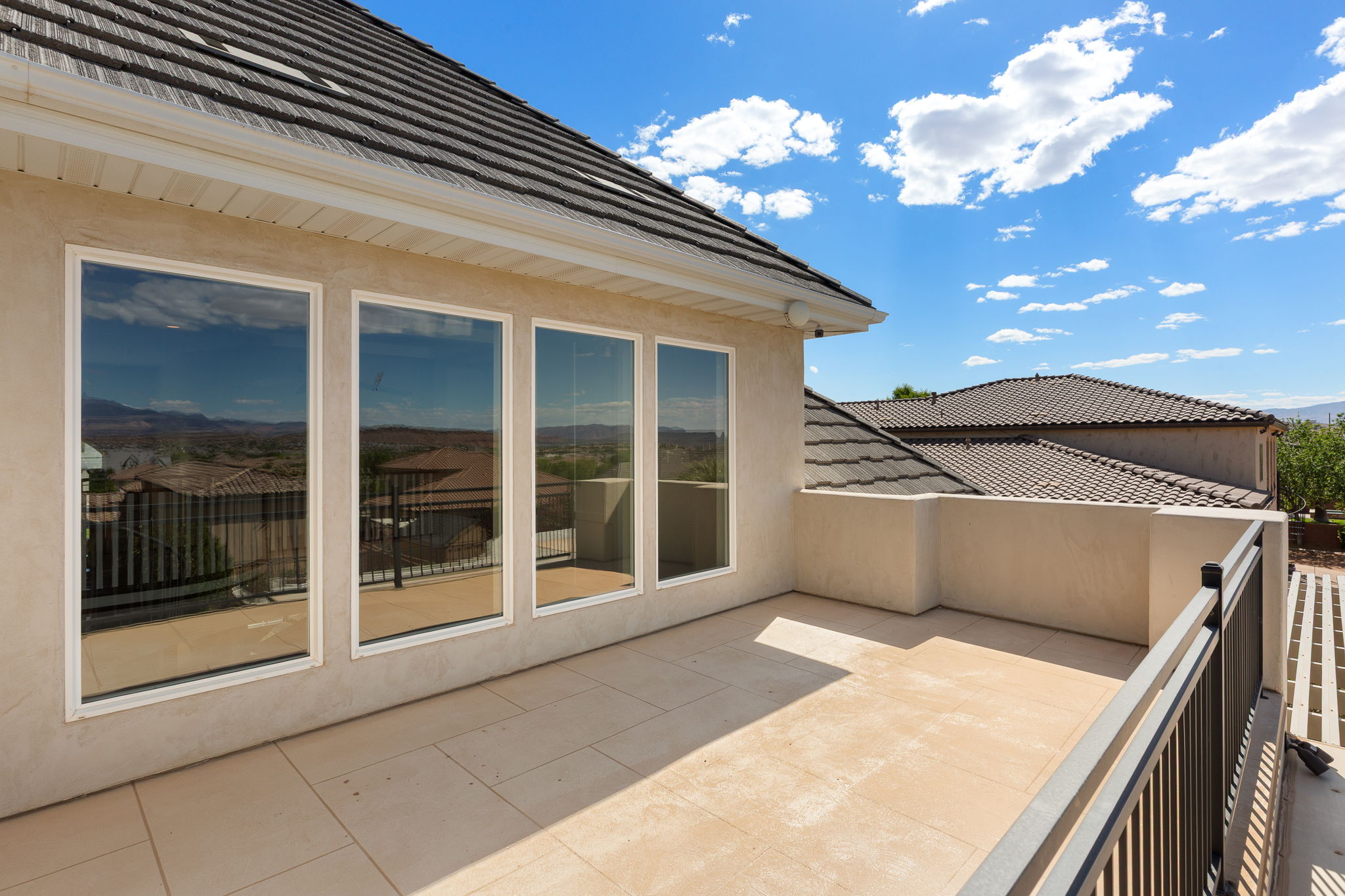 Outdoor balcony featuring a tiled floor and a low stucco wall