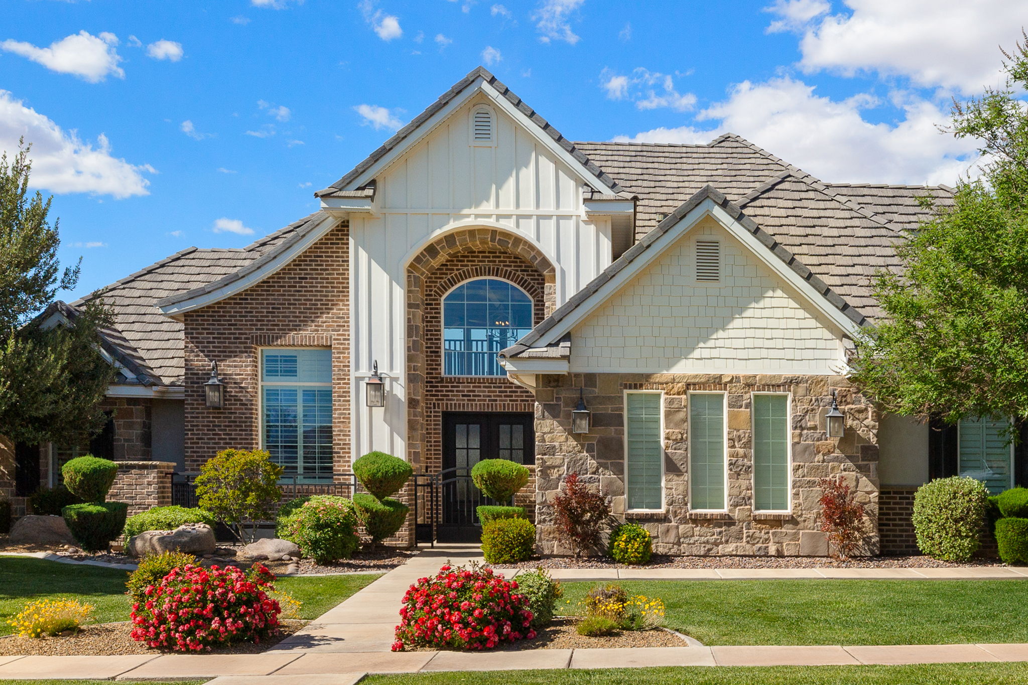 Stately brick and stone facade featuring a prominent arched entry with transom window