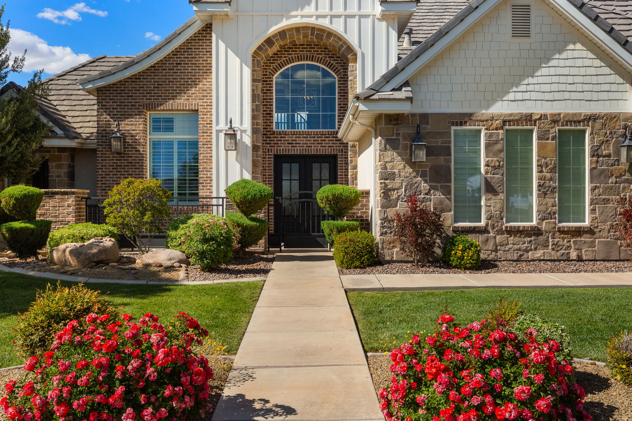 Brick and stone facade featuring a prominent arched entry with double doors