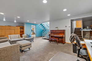 Carpeted room featuring recessed lighting, a built-in wooden storage unit with shelving, and a painted metal staircase with wood treads