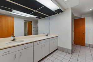 Long vanity featuring dual undermount sinks, chrome fixtures, and ample cabinet storage