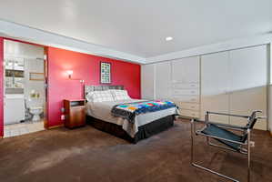 Bedroom featuring a bold accent wall, recessed lighting, and expansive built-in cabinetry with integrated drawers