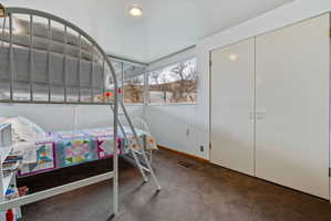 Carpeted room featuring a double-door closet, large windows, and recessed lighting