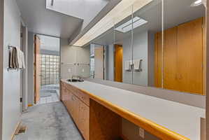 Bathroom vanity featuring extensive counter space and wood-finish cabinetry