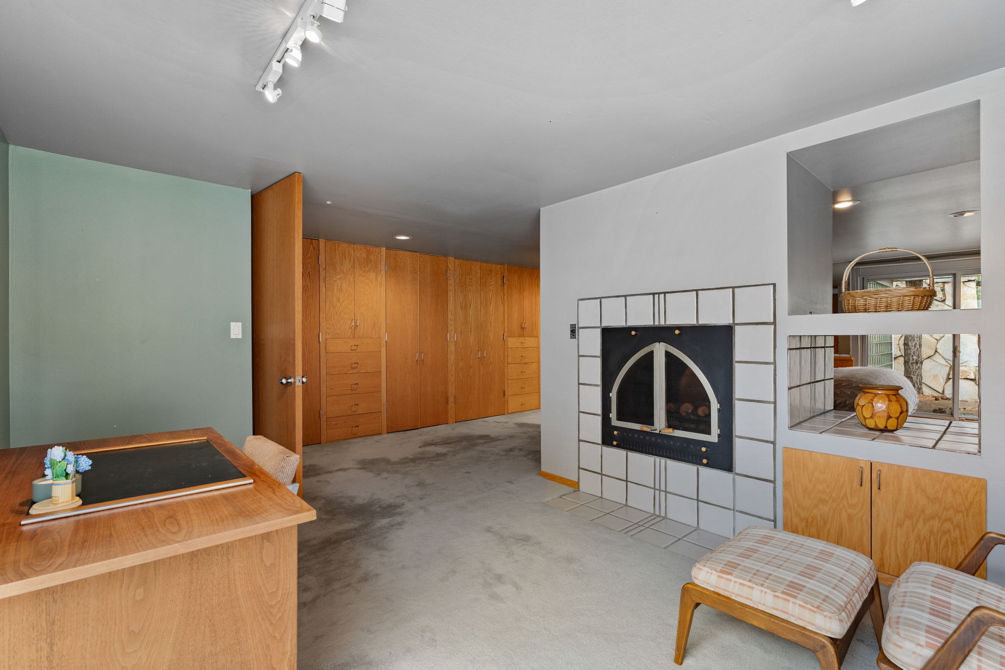 Integrated storage wall with wood-finish cabinetry and drawers