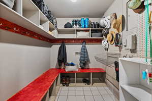 Dedicated storage room featuring multiple built-in shelving units, integrated bench seating, and an extensive pegboard wall
