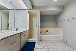 Bathroom featuring a single vanity with storage cabinetry, integrated sink, and wall-mounted mirror