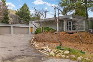 Contemporary architectural style with extensive glass block window walls, a two-car garage, and a bright yellow entry door