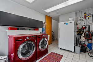 Dedicated utility space featuring a tiled floor, overhead fluorescent lighting, and a wall-mounted pegboard for organization