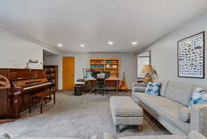 Spacious room featuring light gray walls, recessed lighting, and gray carpeting