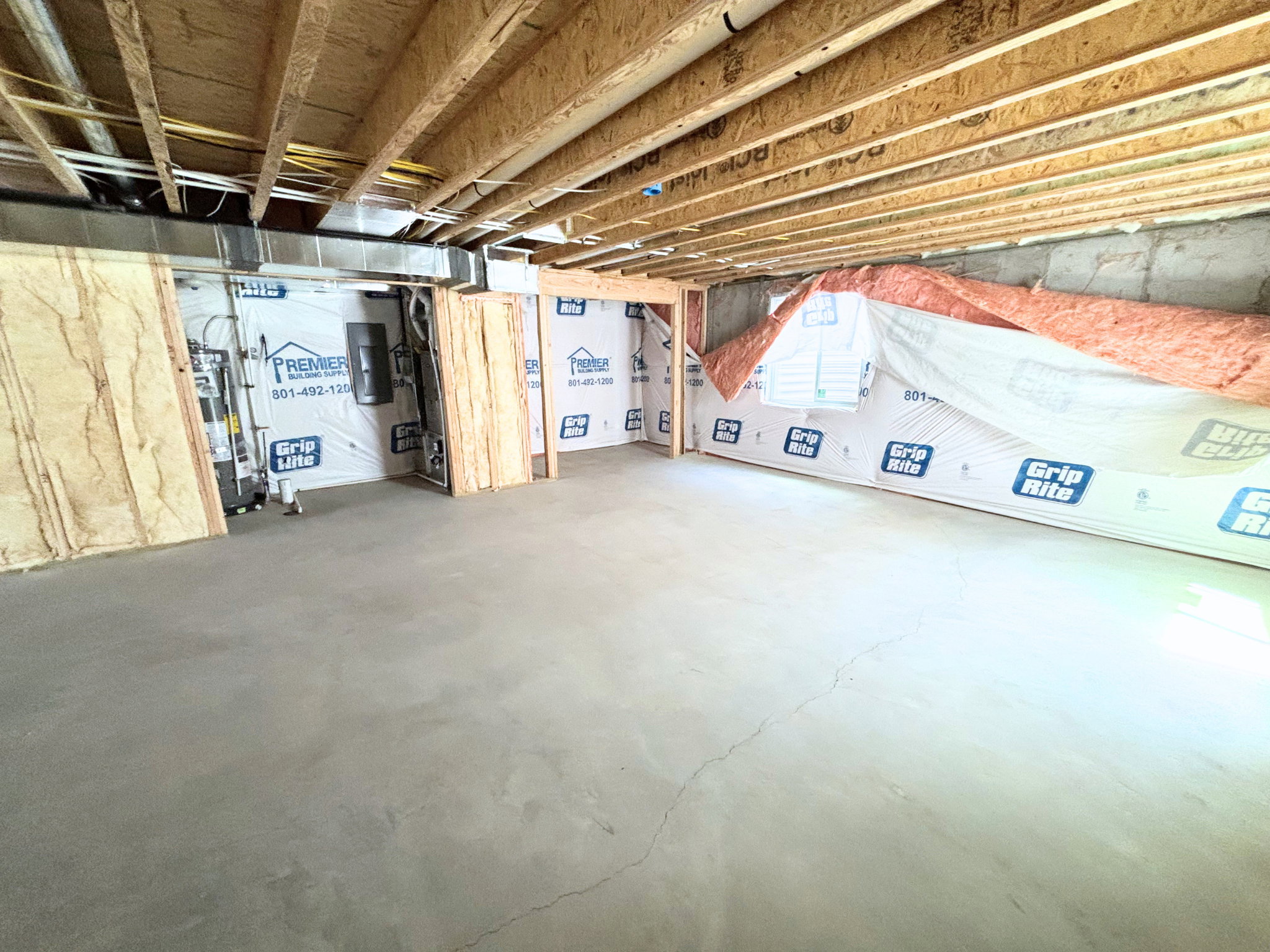 Unfinished basement space featuring exposed wood joists and concrete flooring