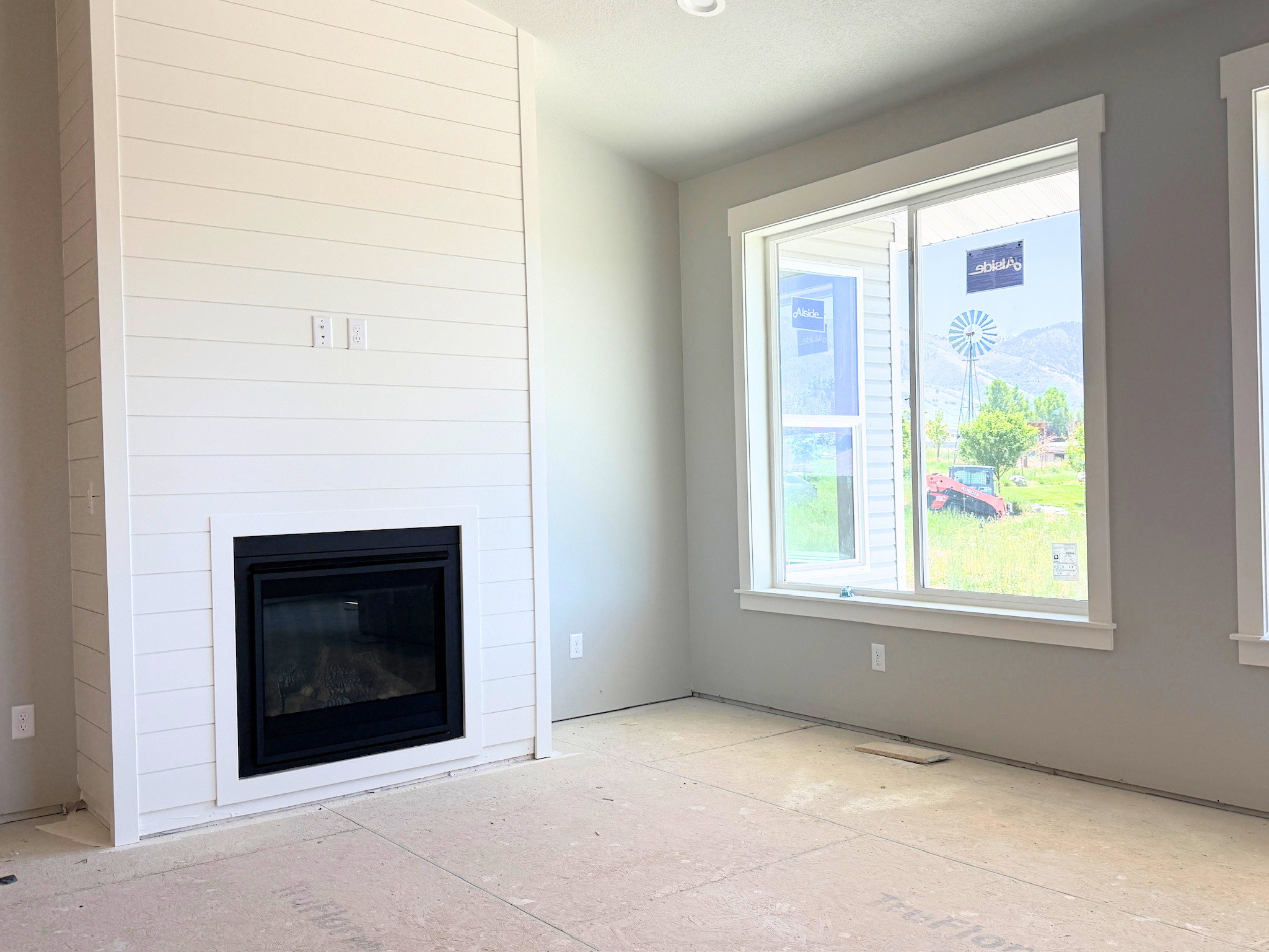 Tall shiplap fireplace surround with a black-framed insert