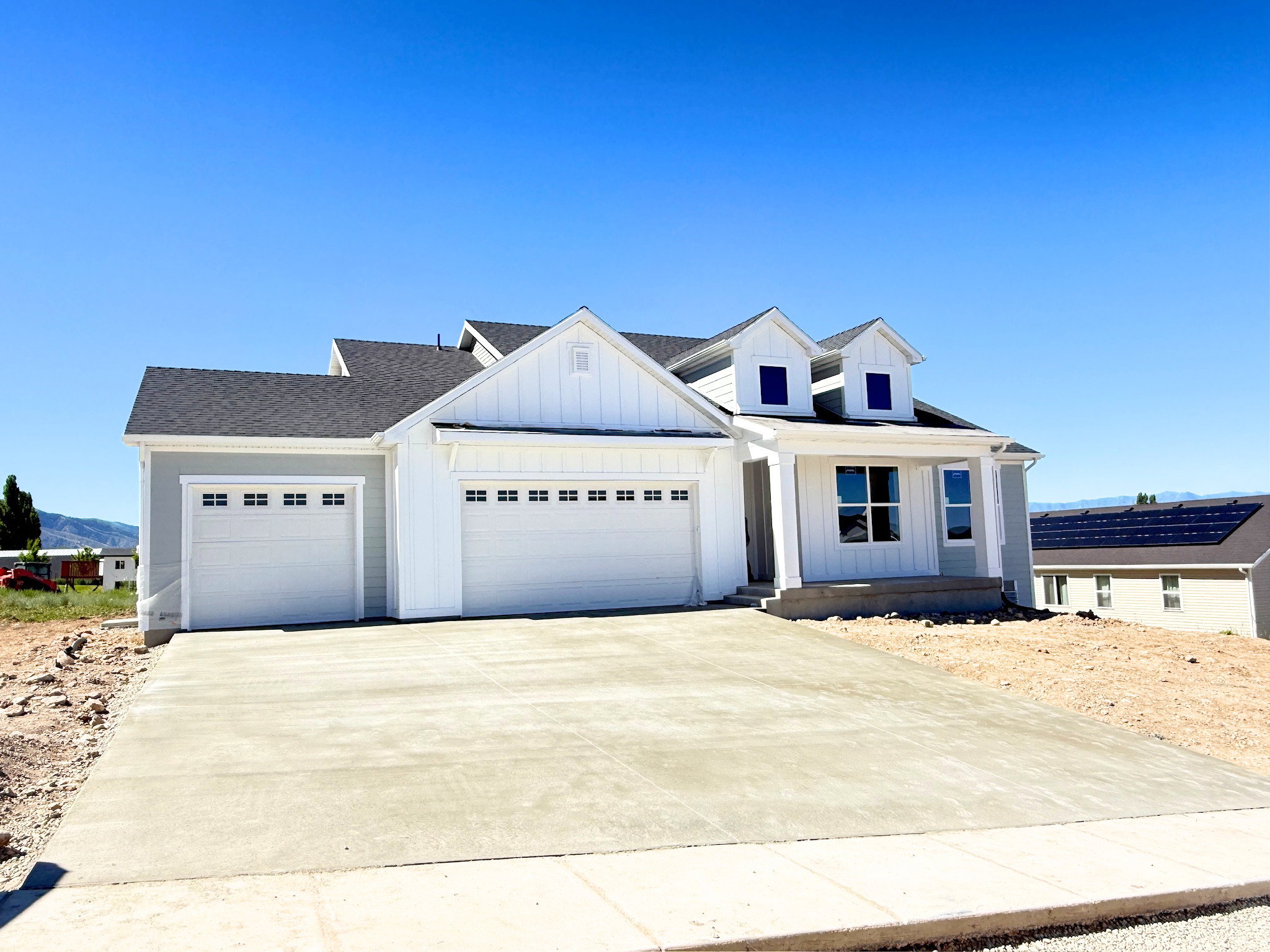 Contemporary residence featuring a two-car garage, an additional single-car garage, and a covered porch entry