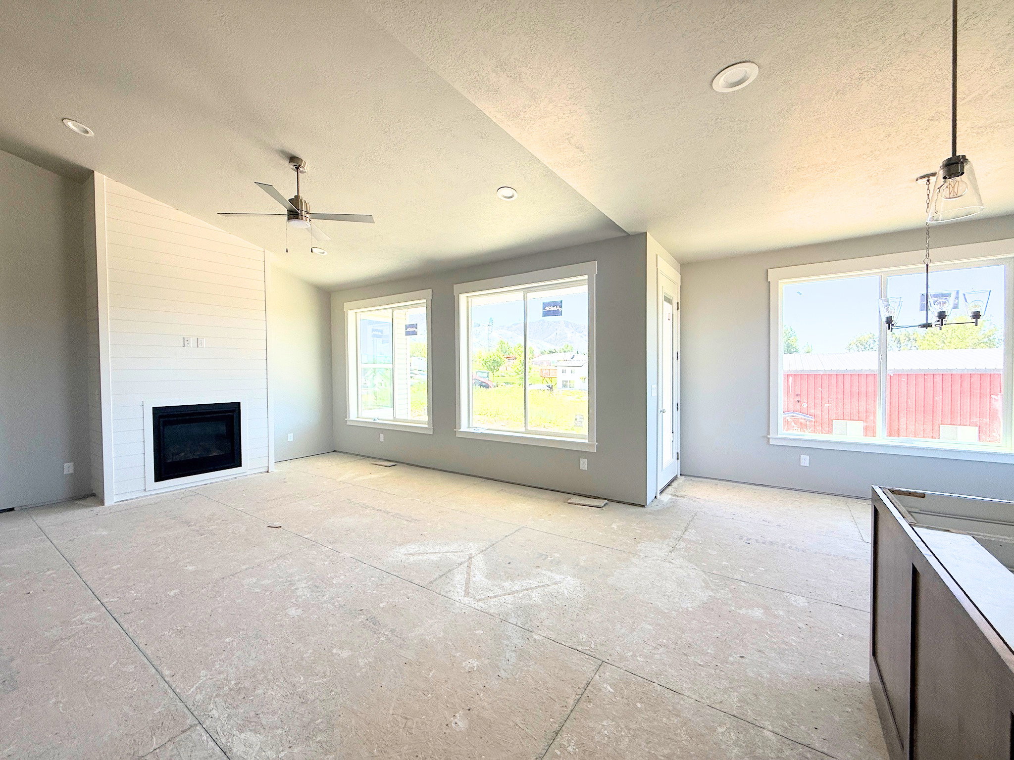 Living area featuring a floor-to-ceiling shiplap fireplace surround, recessed lighting, and a ceiling fan