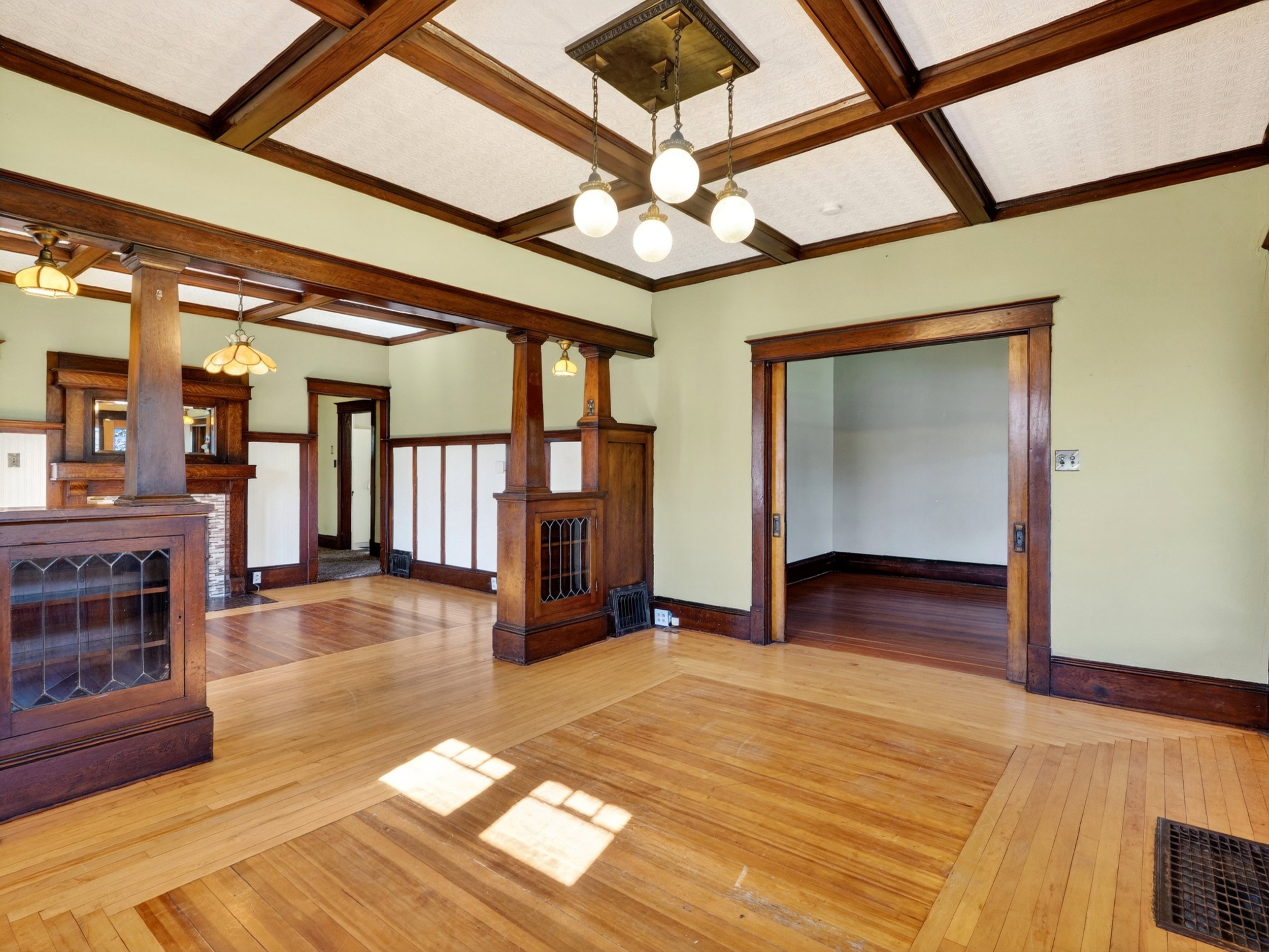 Wood-finish flooring throughout, featuring a coffered ceiling with exposed wood beams and central lighting fixture