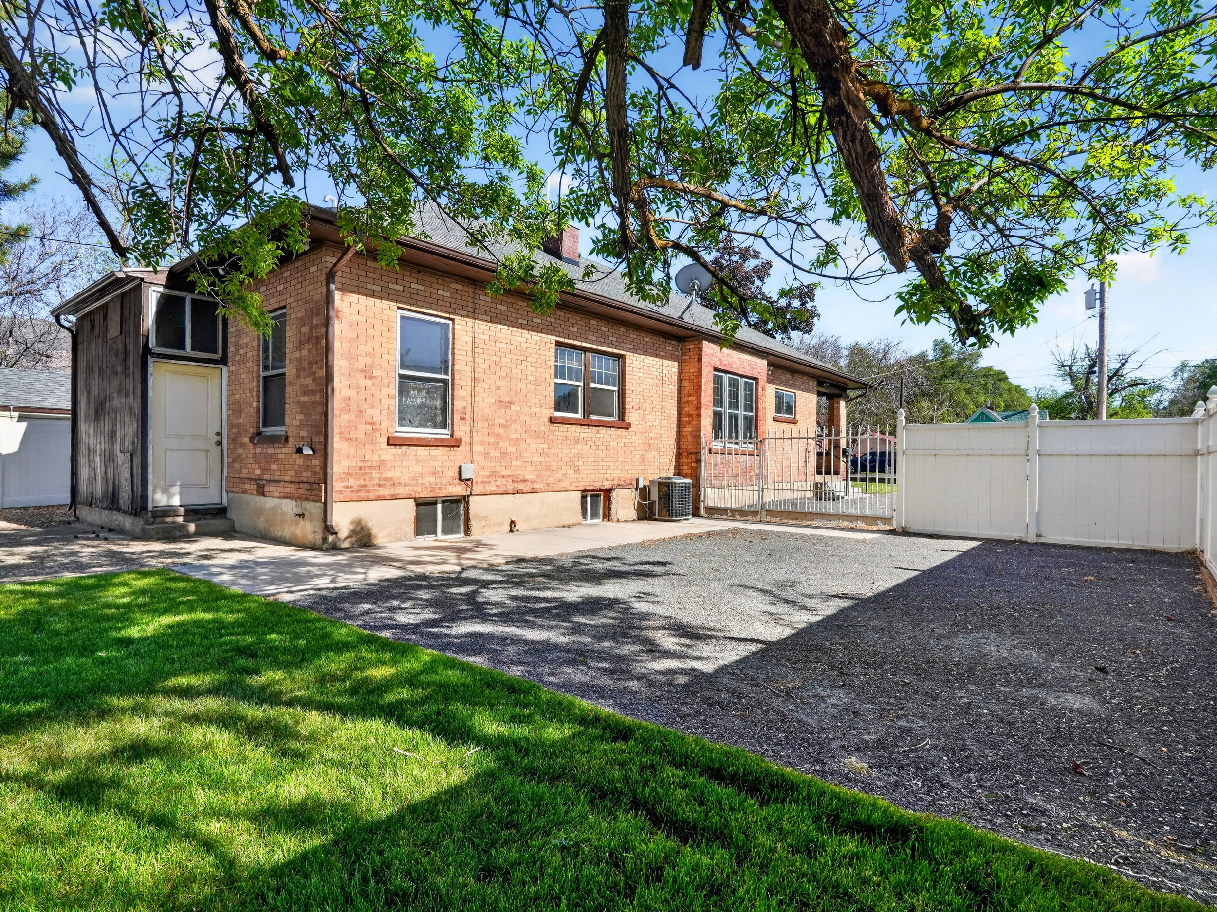 Brick exterior featuring multiple windows and an enclosed porch addition