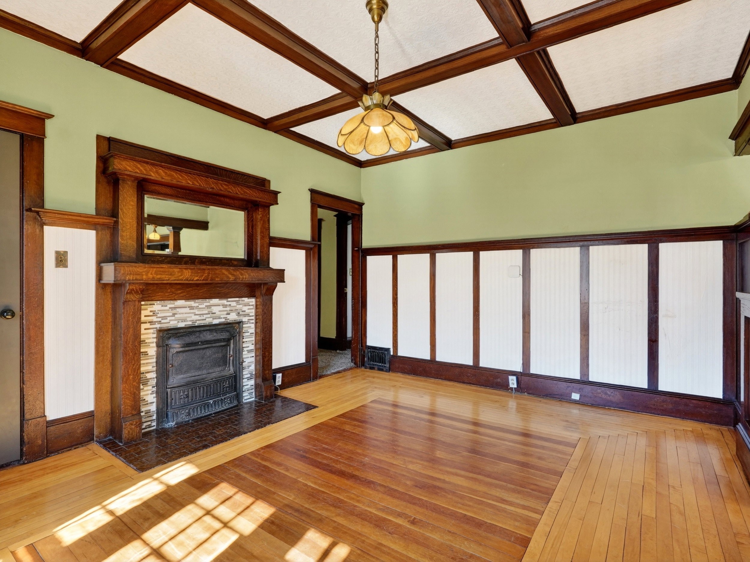 Living area featuring a prominent wood-finish fireplace mantel with an integrated mirror, textured tile surround, and a metal firebox