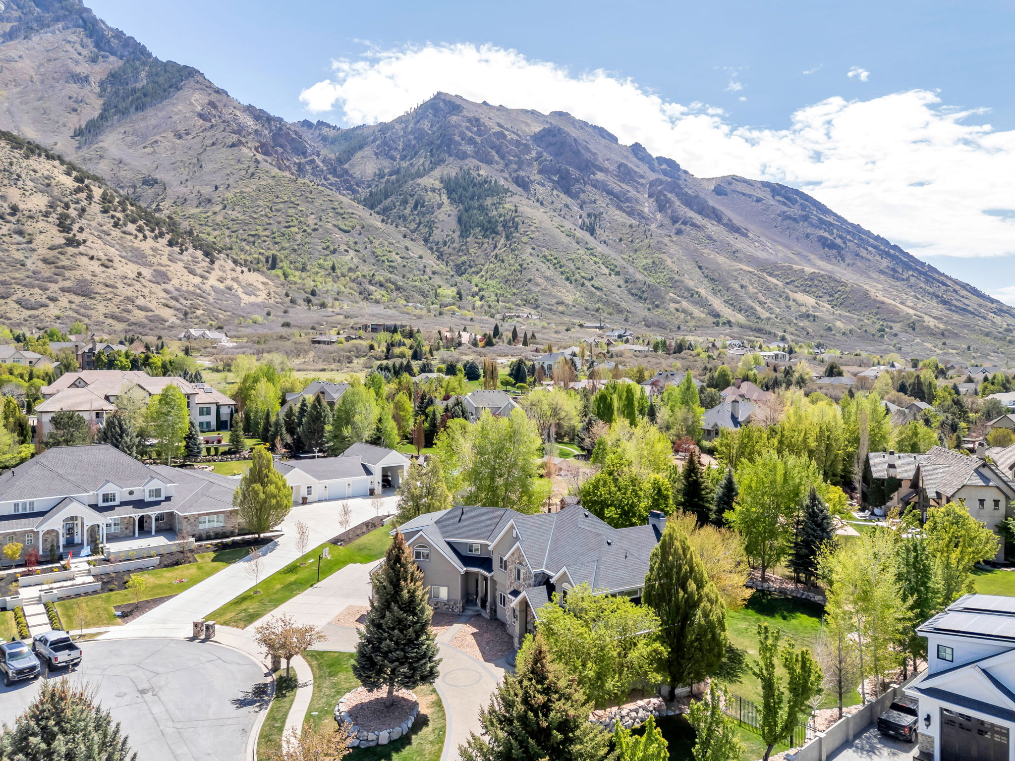Expansive property featuring a stone and siding exterior, a circular driveway, and a multi-car garage
