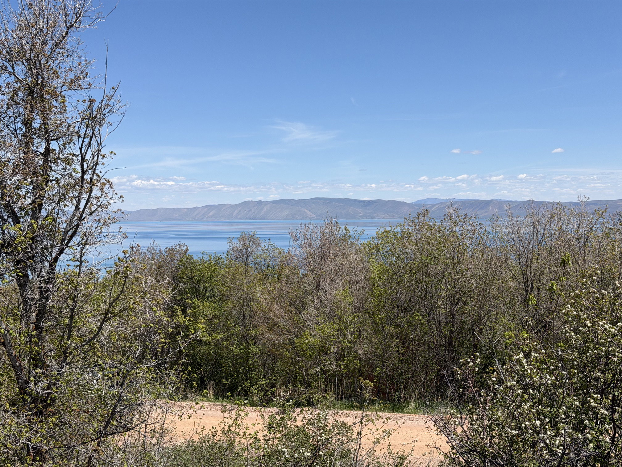 Expansive water body framed by distant mountain ranges under a clear sky