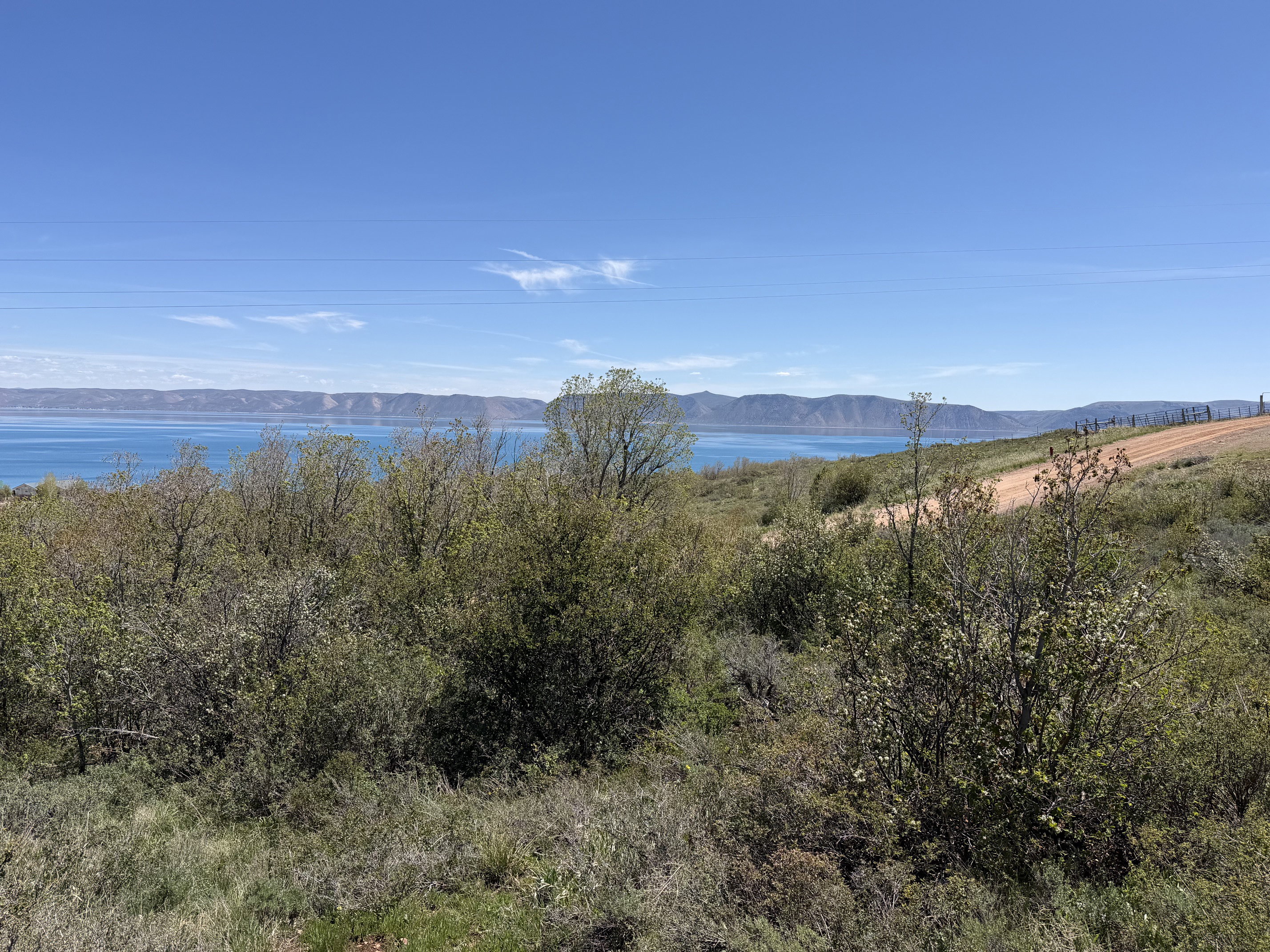 Expansive water body with distant mountains under a clear sky