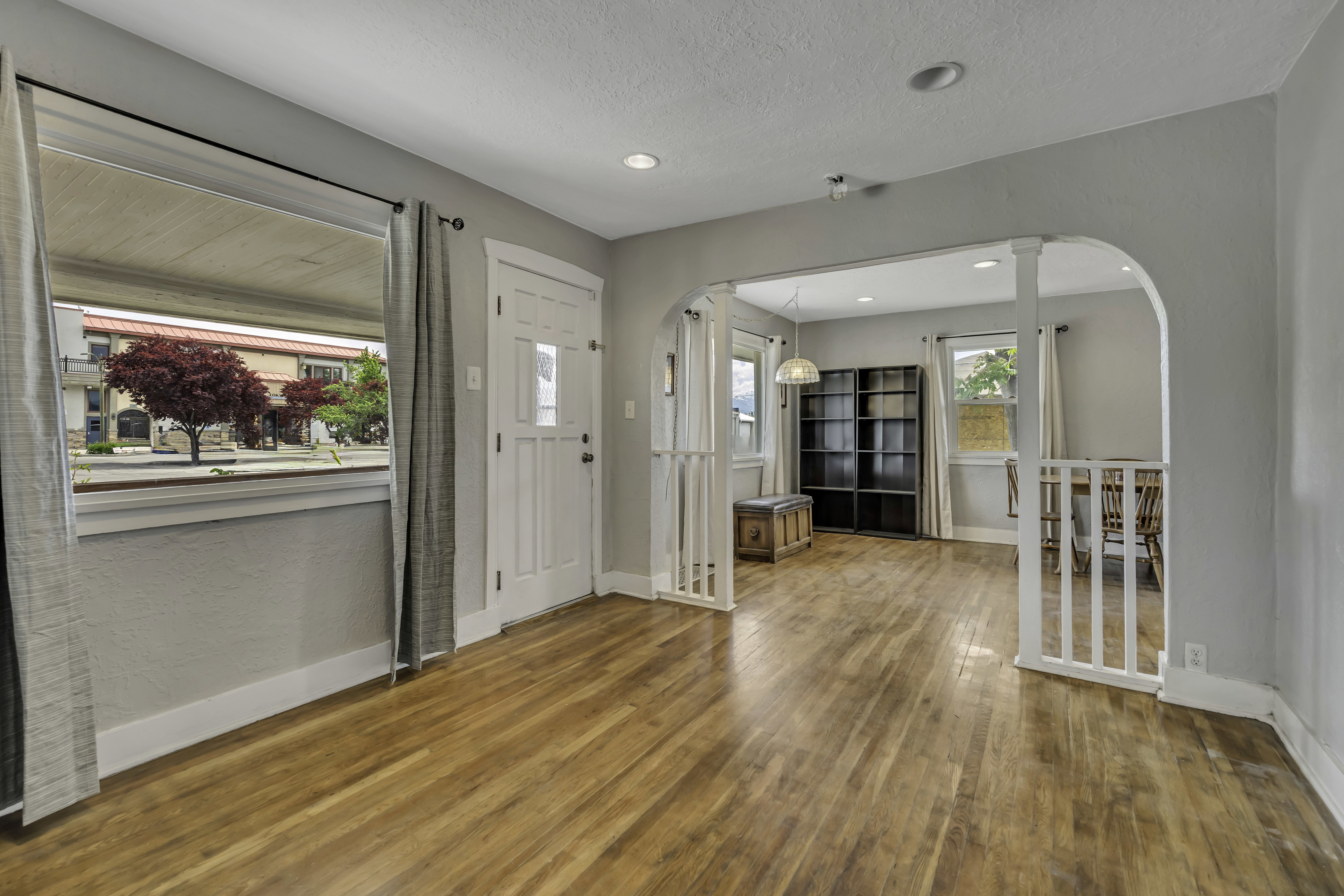 Bright living area featuring wood-finish flooring, light gray wall paint, and recessed lighting
