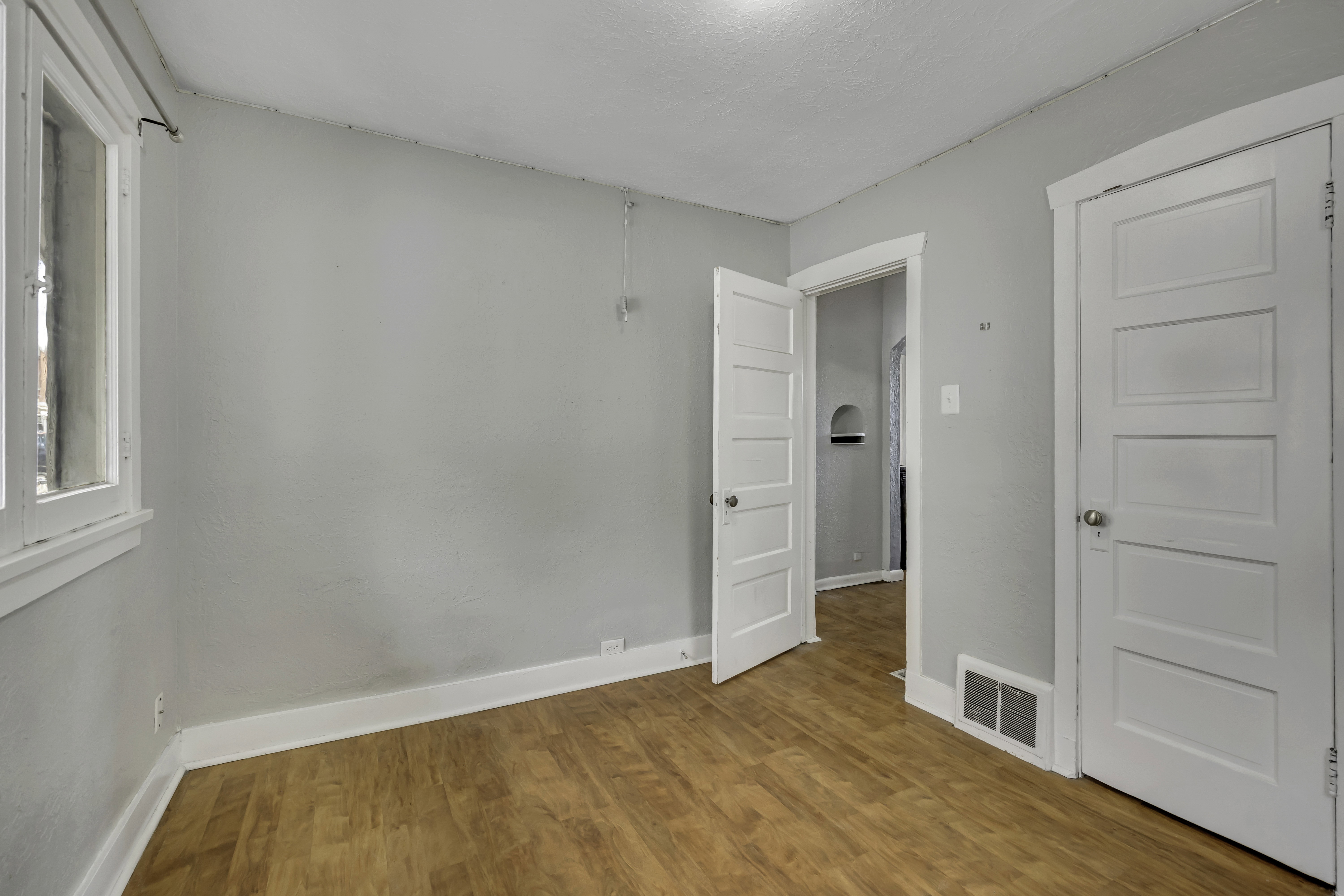 Interior space featuring wood-finish flooring, white baseboards, and light gray walls