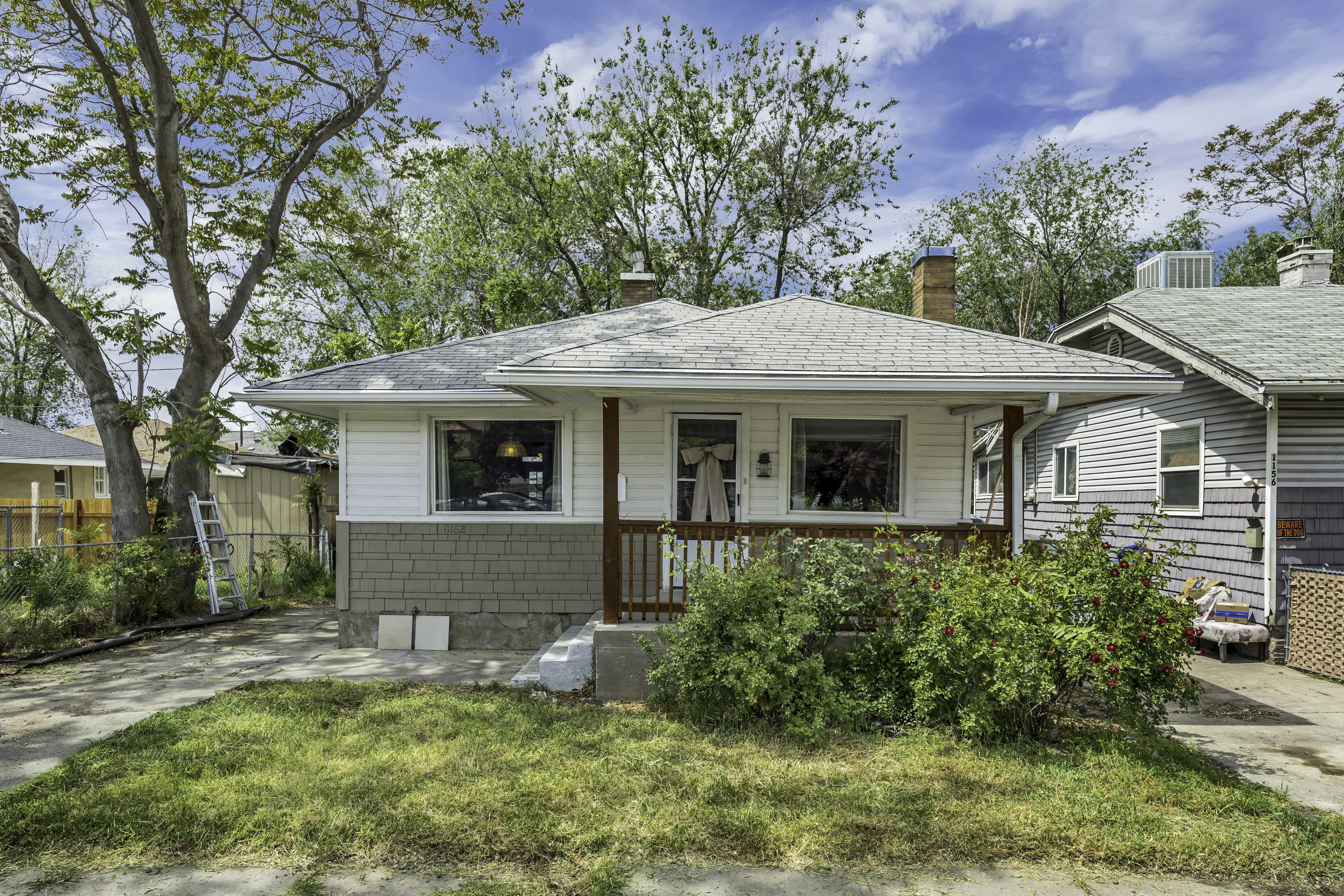 Single-story residence featuring white siding and a contrasting gray textured lower facade