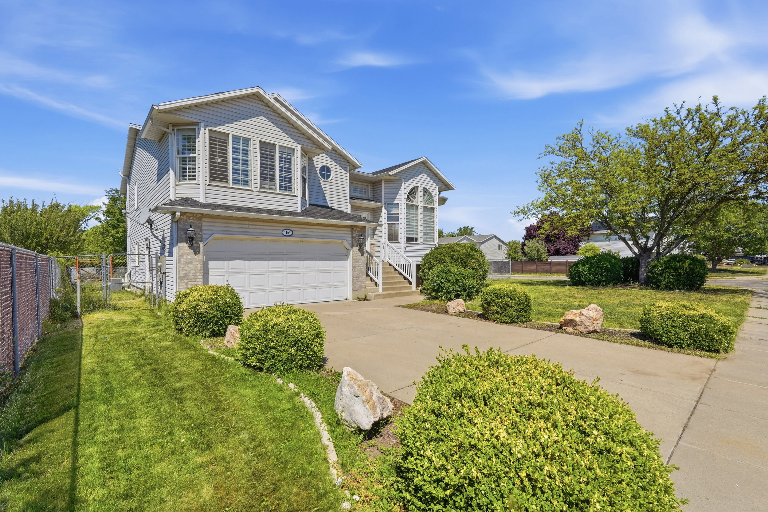 Traditional-style residence featuring light-colored siding and stone accents