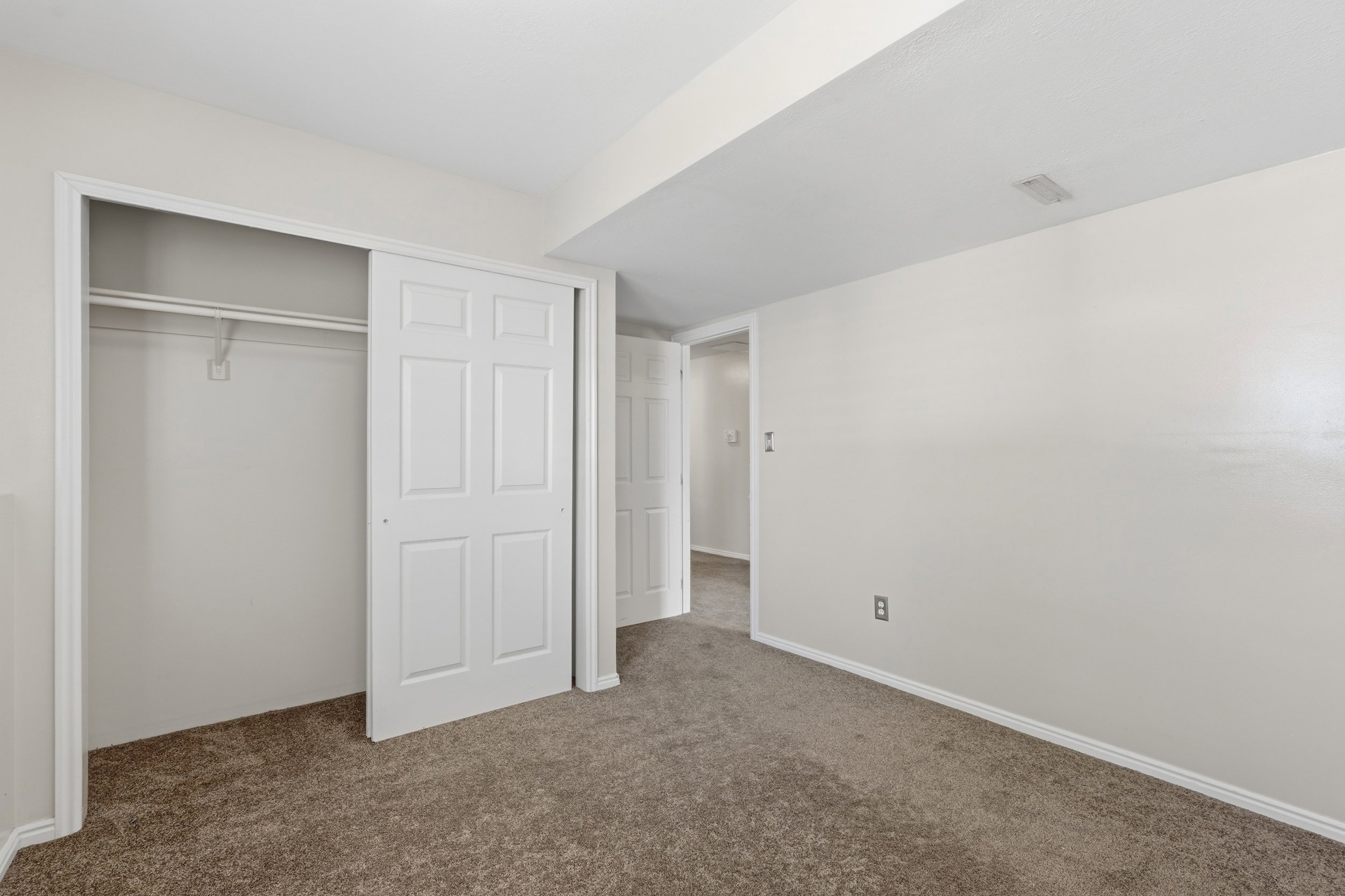 Neutral wall paint, brown carpet flooring, and white trim