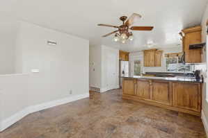 Spacious kitchen featuring wood cabinetry, black countertops, stainless steel appliances, and a central island with decorative detailing