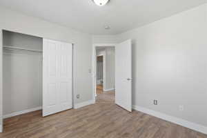 Interior room featuring wood-finish flooring, light grey painted walls, and white baseboards