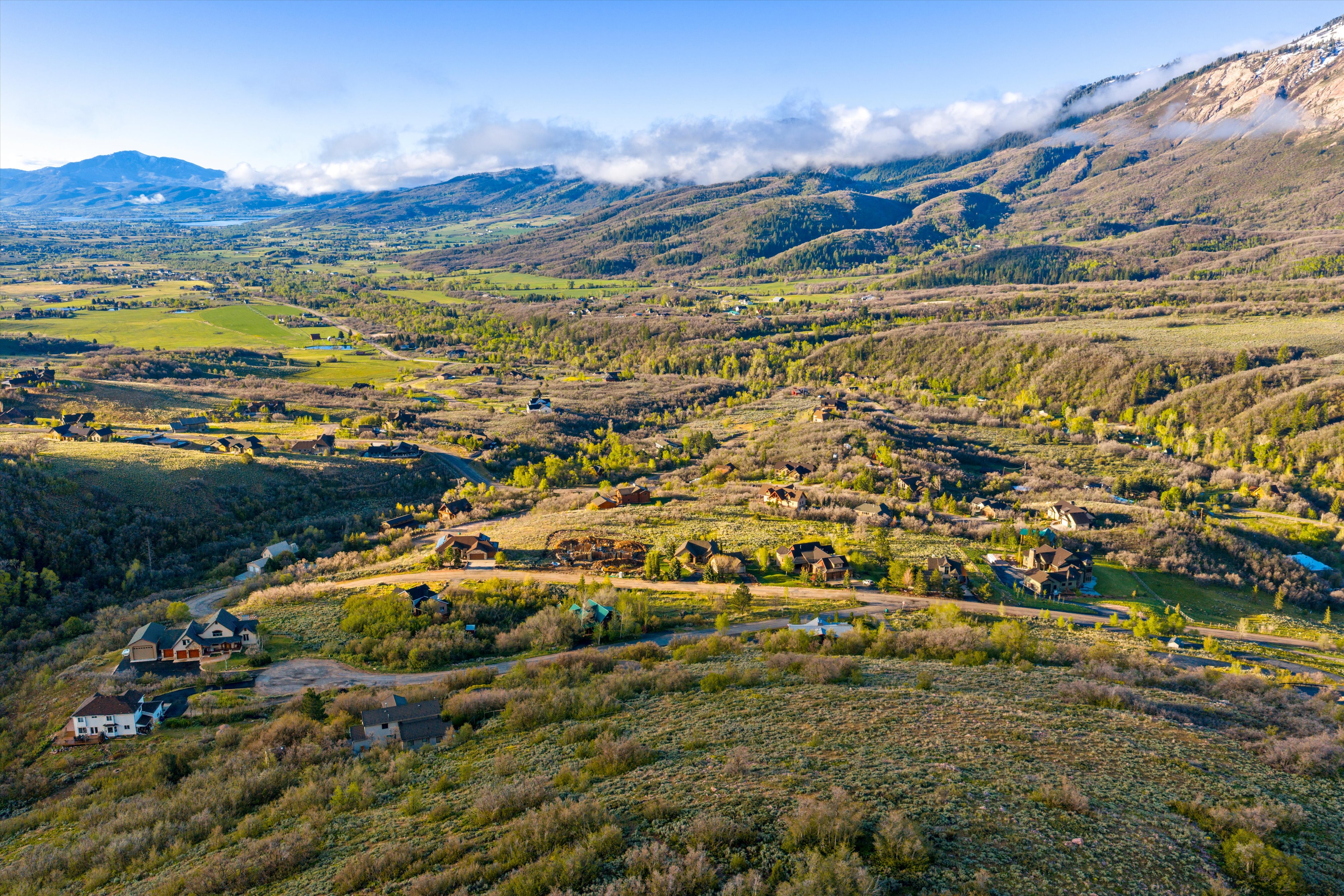 Expansive mountain landscape featuring varied terrain and scattered residential properties
