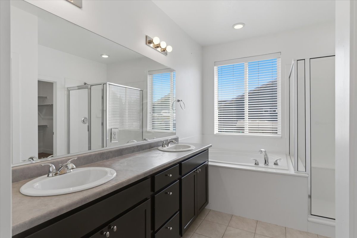 Double vanity with dual undermount sinks, extended countertop, and dark wood cabinetry