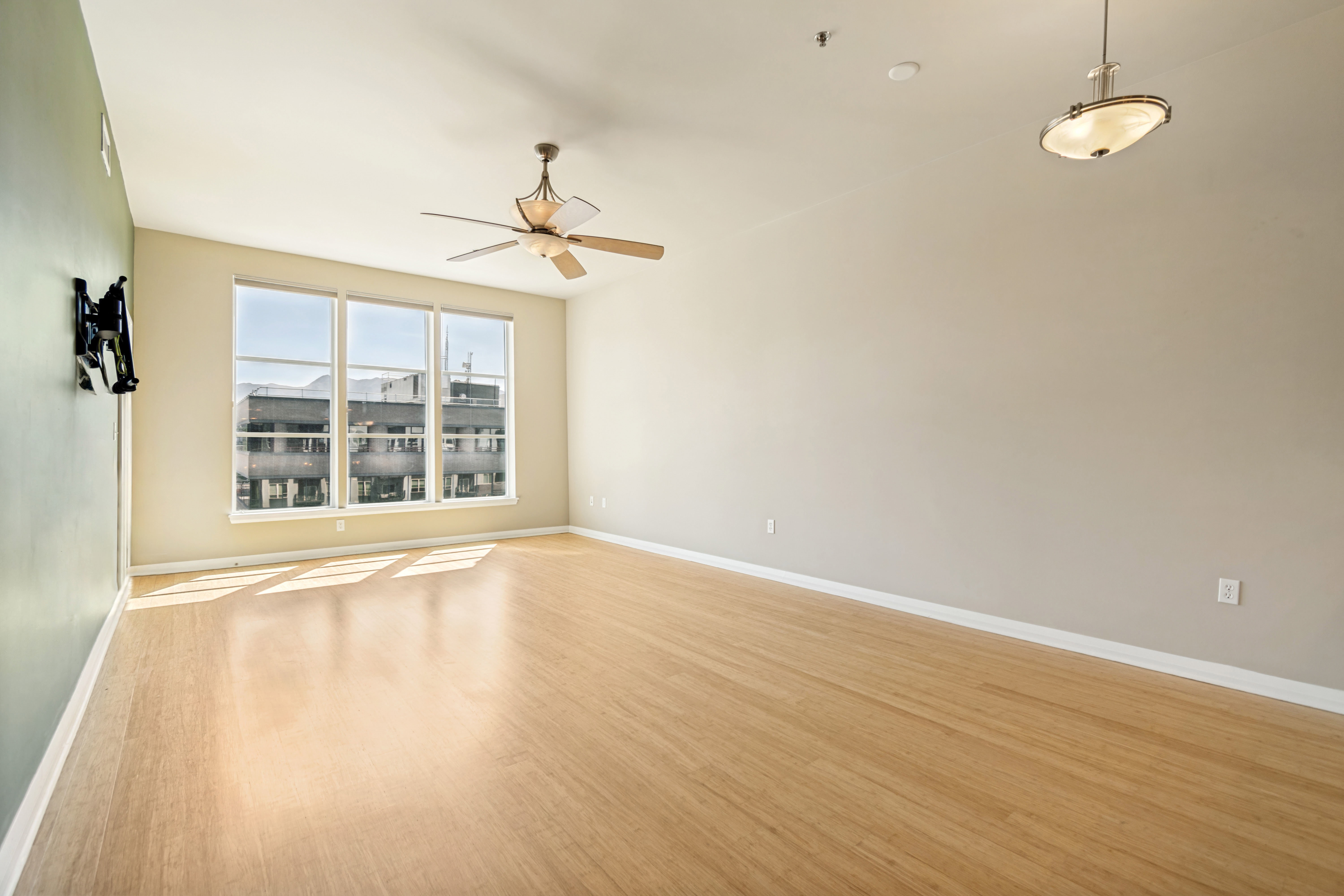 Spacious interior with wood-finish flooring, large windows, and high ceilings